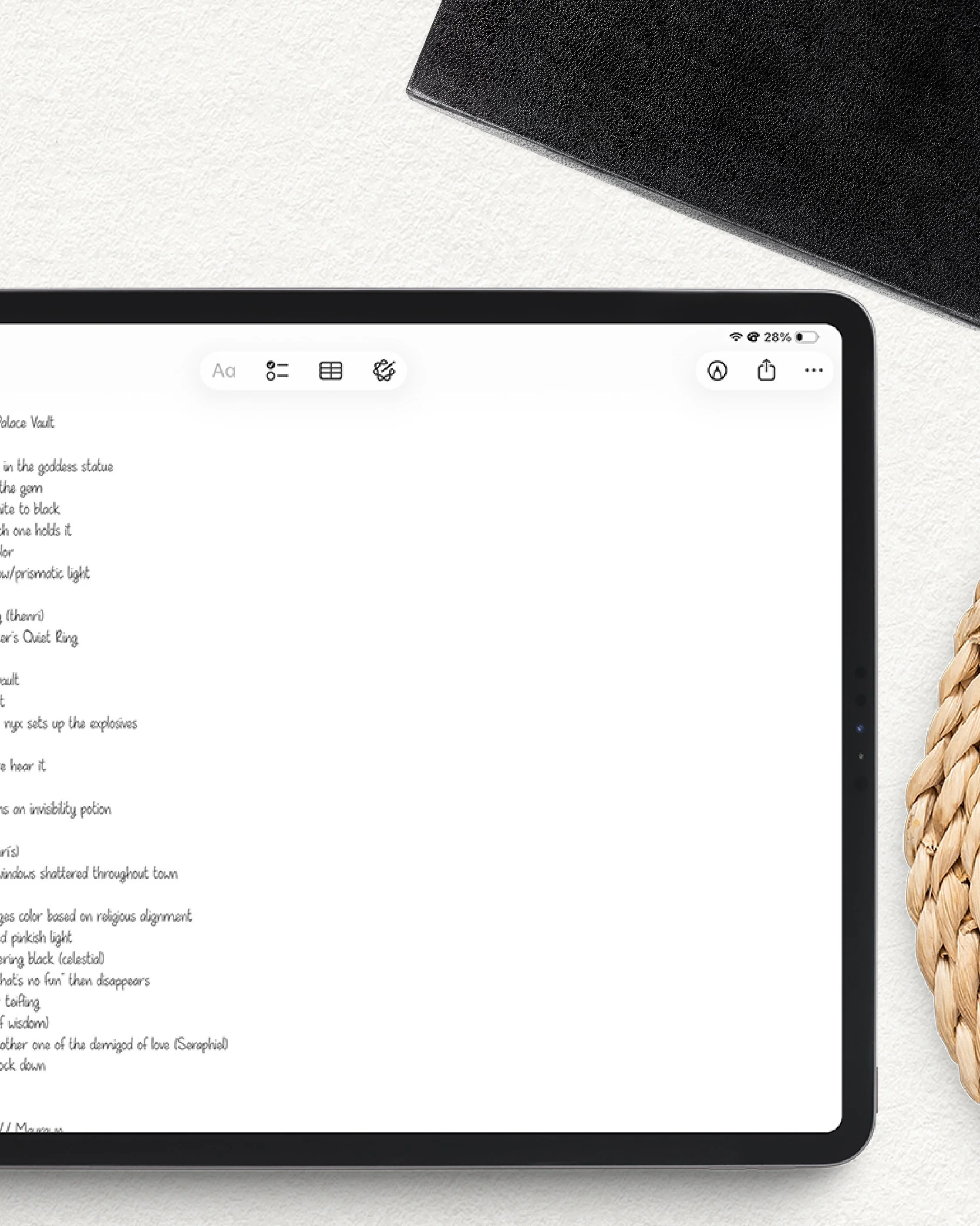 Close-up of a tablet screen displaying text, with a woven object on the right side and a black textured object on the top corner, all on a white surface.