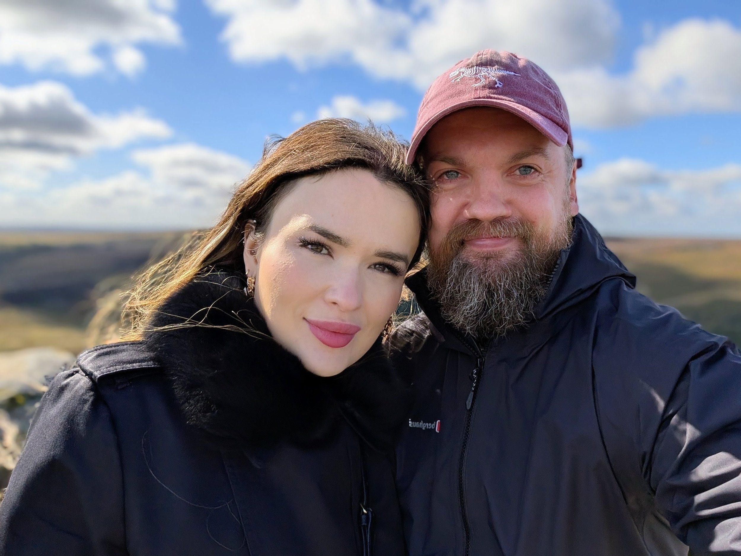 Paul Thomas with his wife, founders of The Human Co., standing outdoors with blue sky background