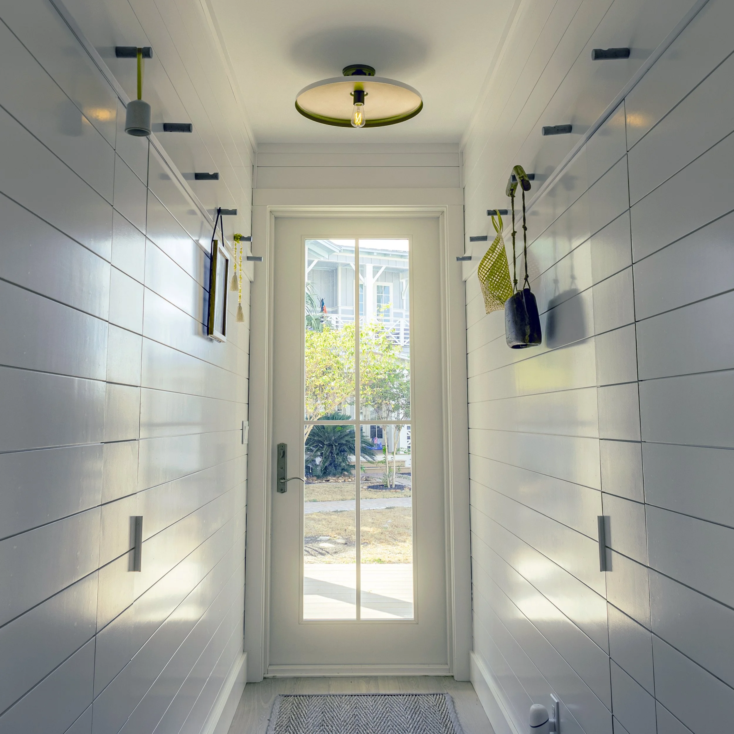 Shiplap Traditional Coastal Home Entry Hallway Hidden Closets Shaker Hanging Concrete Custom Hooks. Marco Polo Lane Project, Cinnamon Shore North. Port Aransas, Texas - residential design by licensed architect Stefanie Mustian, Board and Batten Archi
