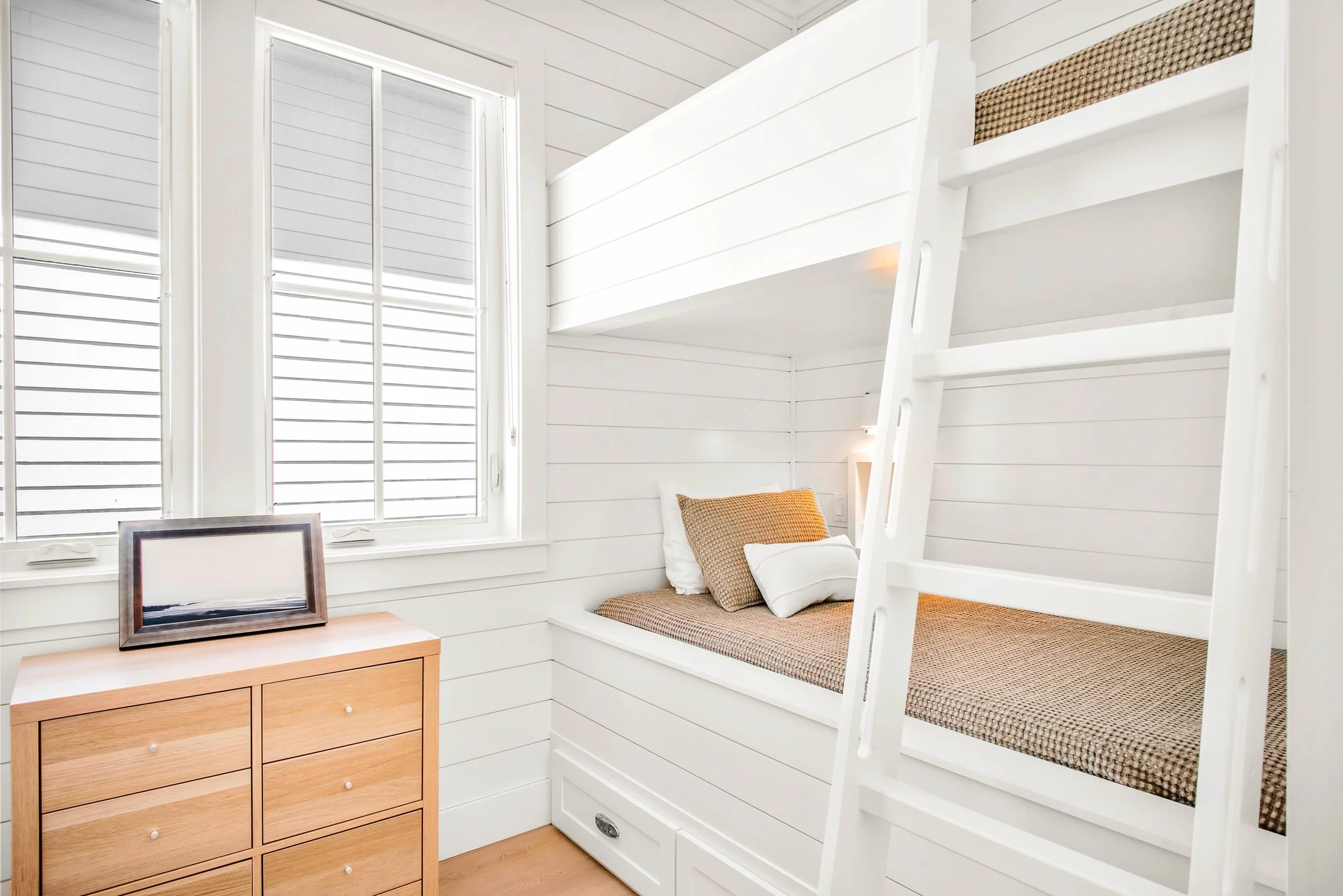 Modern Traditional Bunk Room with Board and Batten, Sturdy Angled Built-In Ladder. White Bunk Room. Marco Polo Lane Project, Cinnamon Shore North. Port Aransas, Texas - residential design by licensed architect Stefanie Mustian, Board and Batten Archi