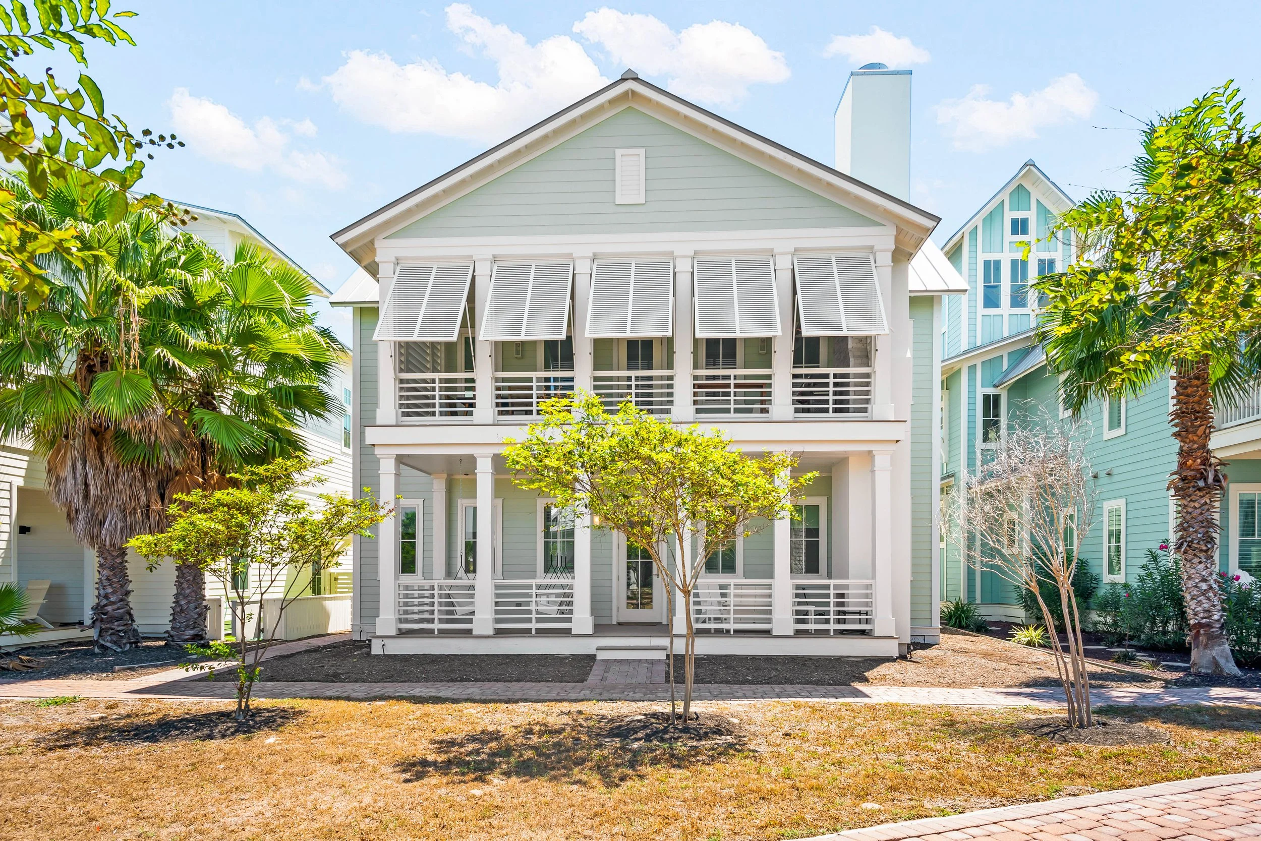 Traditional Coastal Classical Home Pediment Columns Front Bahama Shutters. Marco Polo Lane Project, Cinnamon Shore North. Port Aransas, Texas - residential design by licensed architect Stefanie Mustian, Board and Batten Architecture and Design.