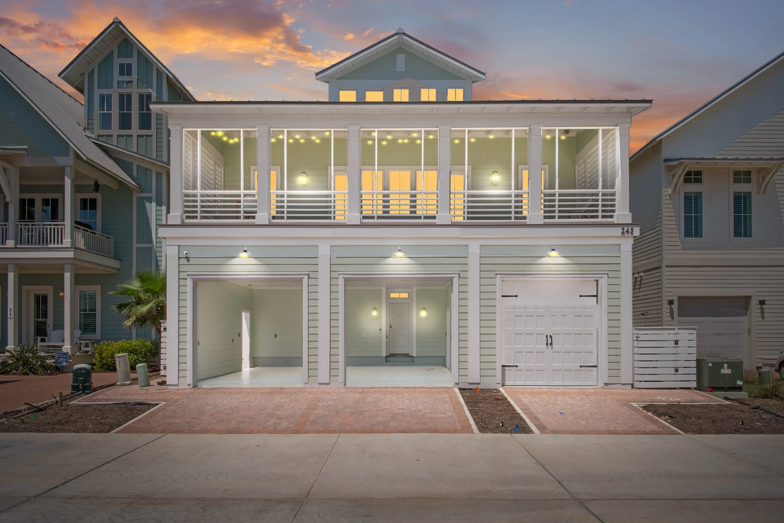 Modern Traditional Coastal Home, Double Porch with Columns, String Lights, Night Time. Marco Polo Lane Project, Cinnamon Shore North. Port Aransas, Texas - residential design by licensed architect Stefanie Mustian, Board and Batten Architecture and D