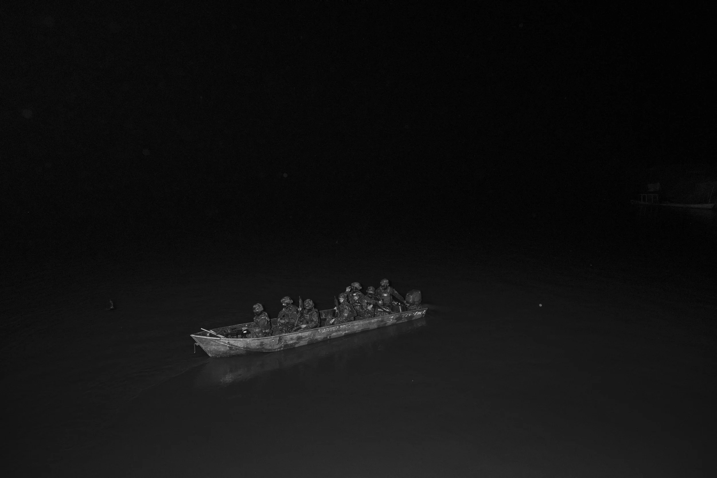 A squad of Brazilian Army soldiers patrols the Solimões River by boat after leaving the riverine community of Capacete, where the Army has established a floating outpost to monitor and inspect vessels navigating the river at night.