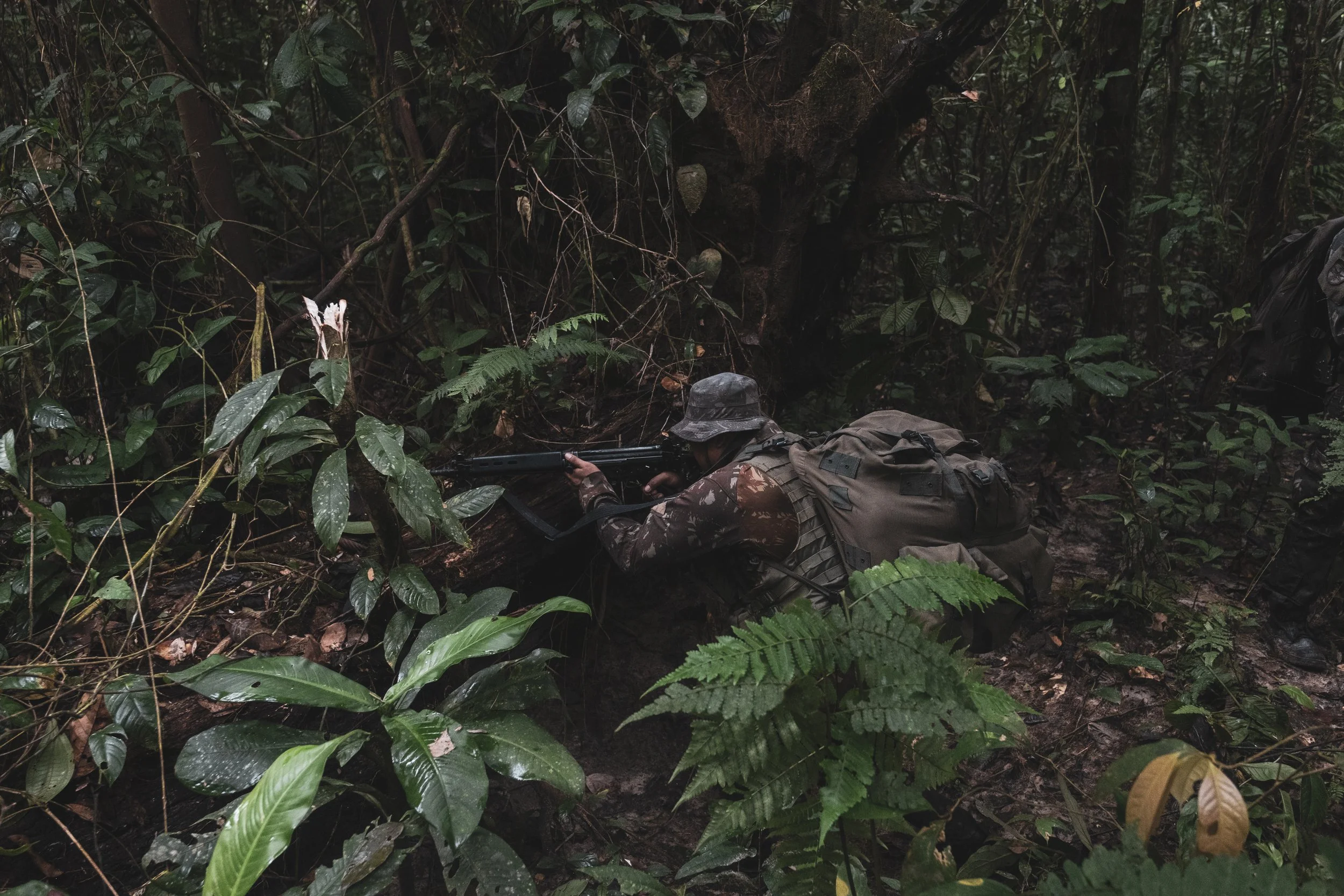 A member of the Brazilian Army’s special operations jungle unit, Selva, takes position after hearing noises inside the forest during a patrol operation along a jungle trail near the Colombian border, where Brazilian forces recently engaged with the C