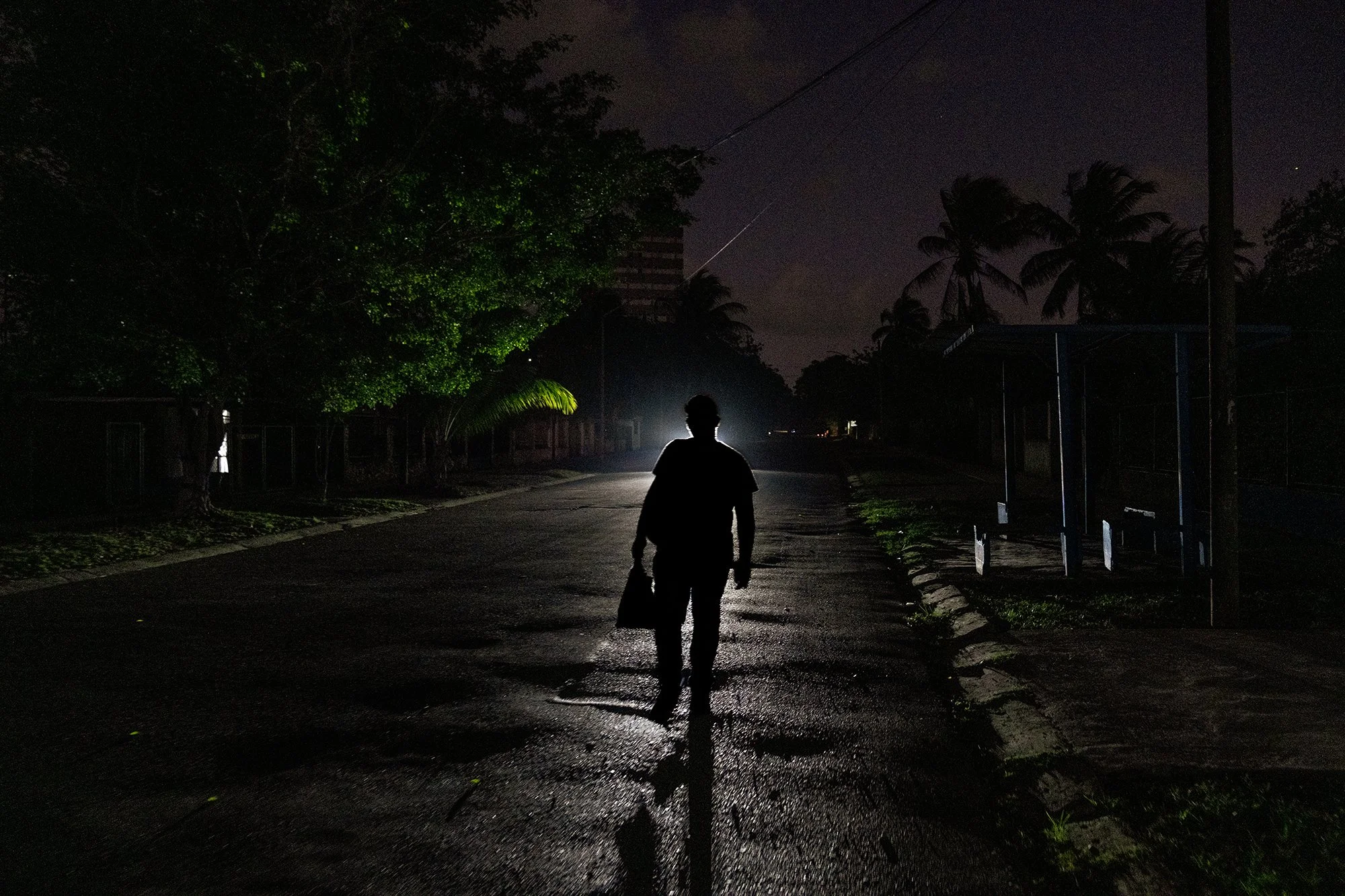 A man walks along a street at night in Alamar, a large residential district in eastern Havana, during a blackout.