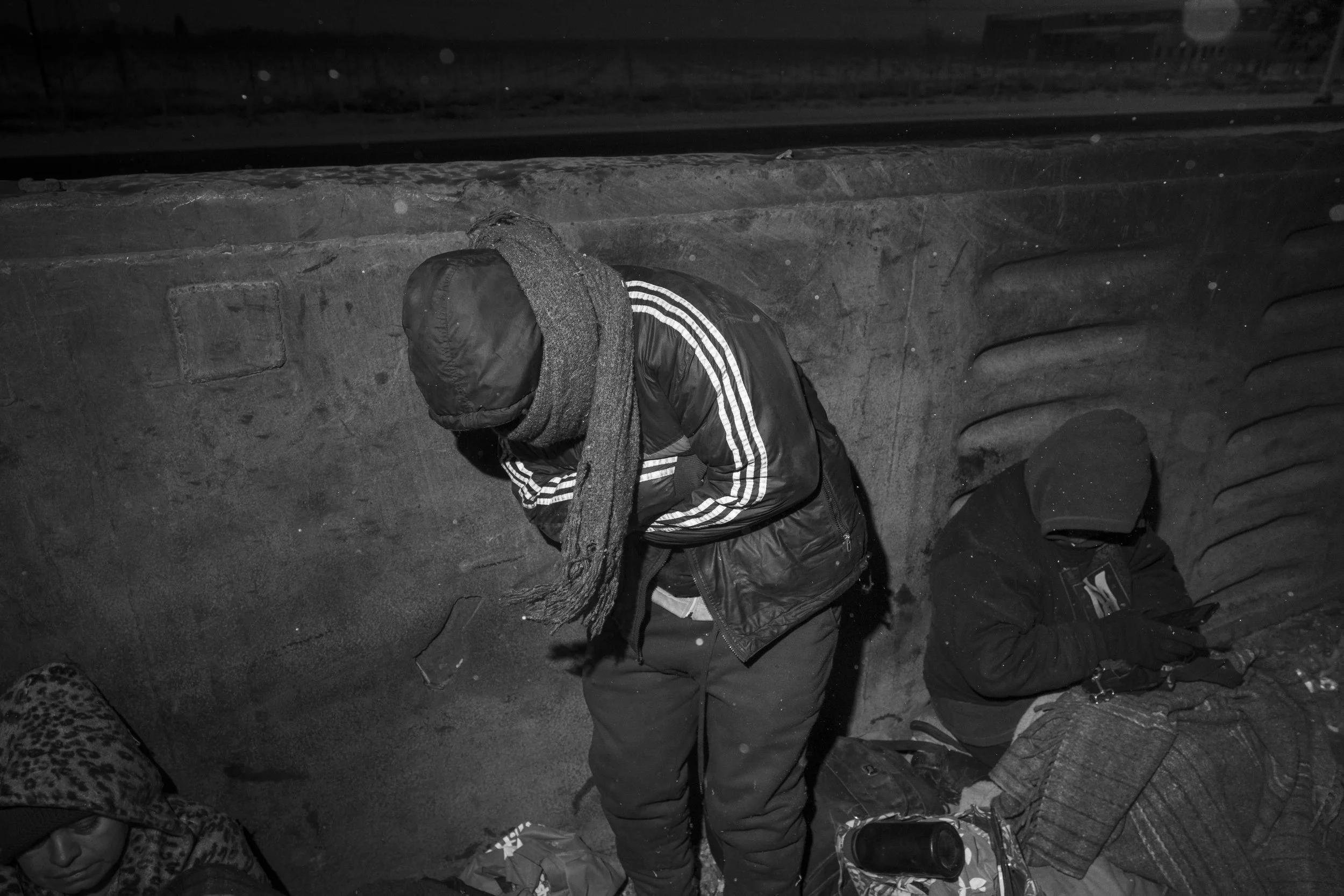 Cesar Atencio braces against the extreme cold as he travels aboard a freight train toward Chihuahua.