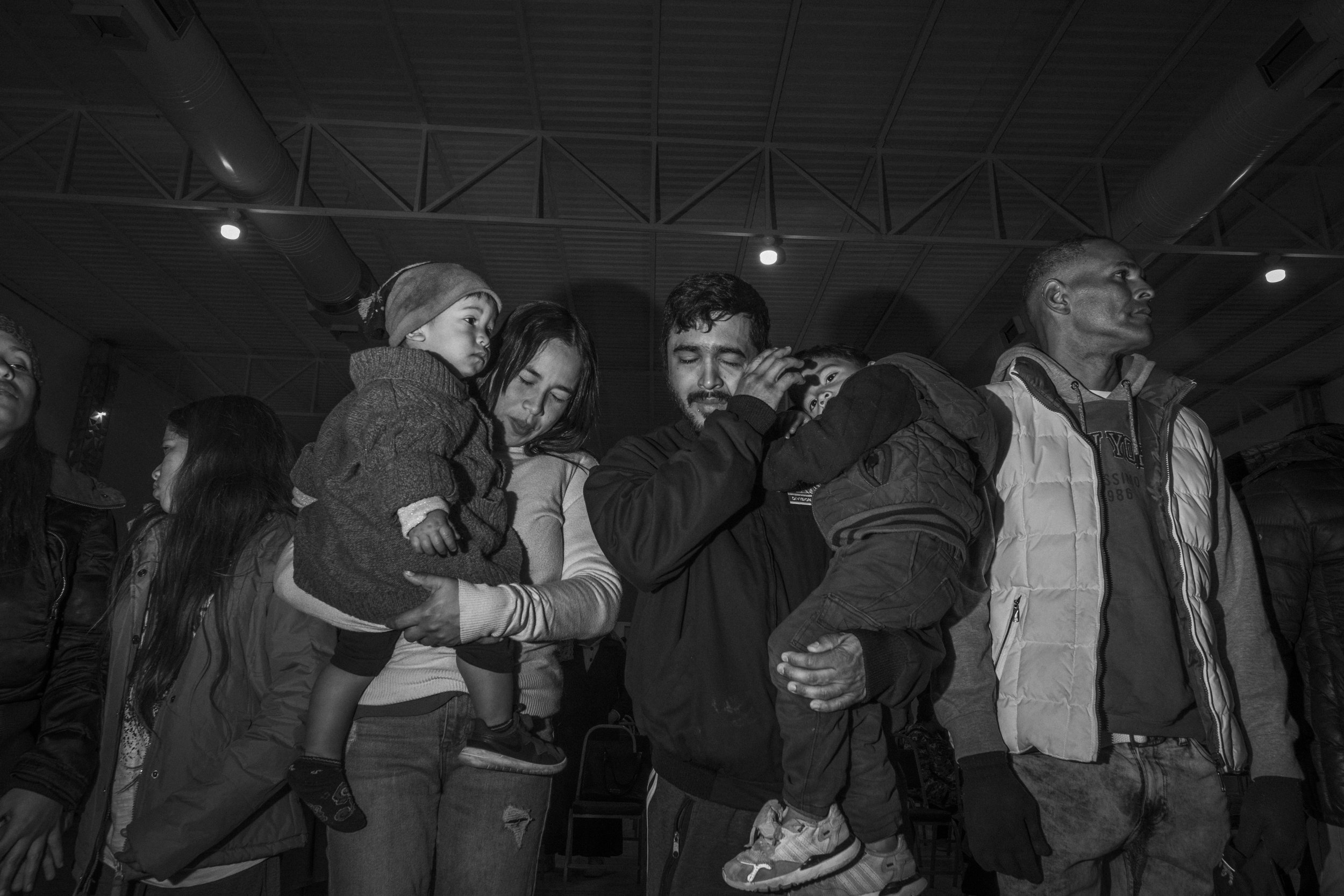 Cesar Atencio and Lina Arias cry and pray during an evangelical worship service while holding their sons, Simon and Angel, in a church in Torreón, Mexico. 