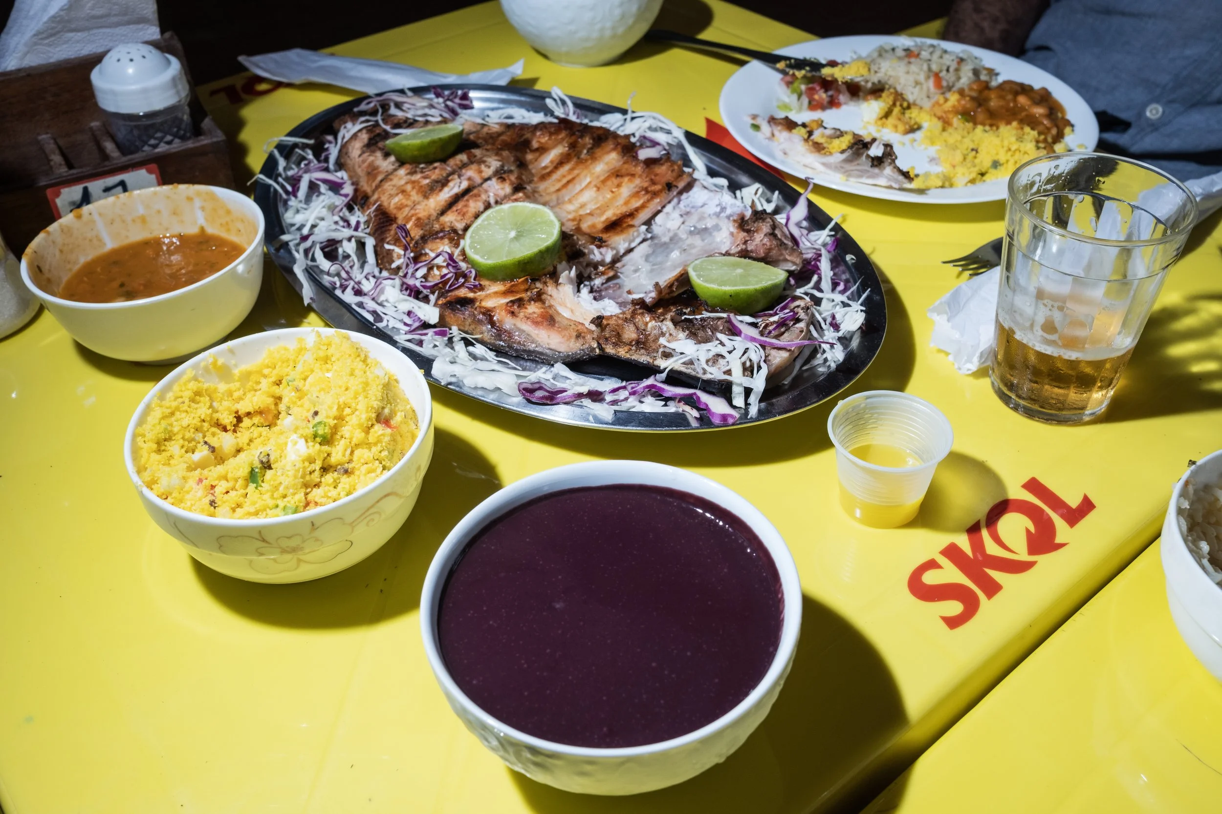 Uma refeição típica amazônica com açaí, peixe tambaqui, farofa, arroz e feijão, servida em um restaurante na Ilha do Combu — uma comunidade ribeirinha localizada do outro lado do rio, em frente a Belém.