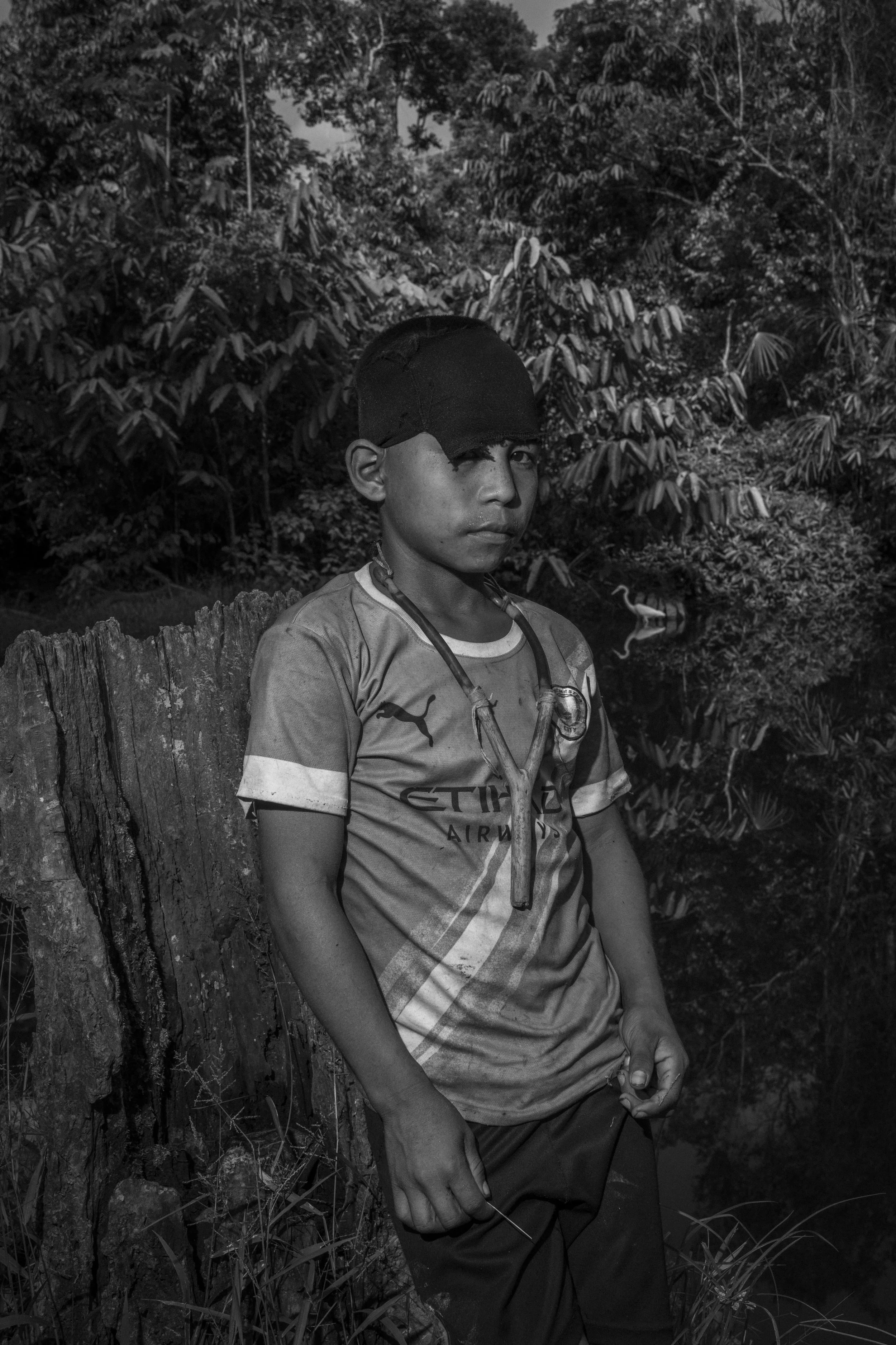 A Mayoruna child holding a slingshot in Aldeia Flores, a Mayoruna Indigenous village along the Curuçá River within the Javari Indigenous Territory, Brazil.