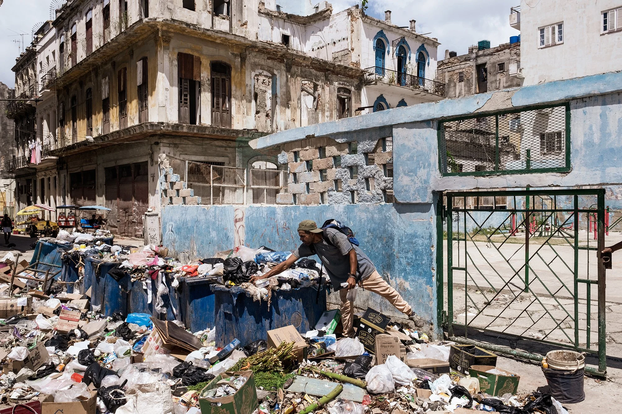 A man searches for food and other items among piles of uncollected waste on a street in downtown Havana. Due to fuel shortages and the ongoing economic crisis, trash collection has been severely disrupted, leaving garbage accumulating across the city