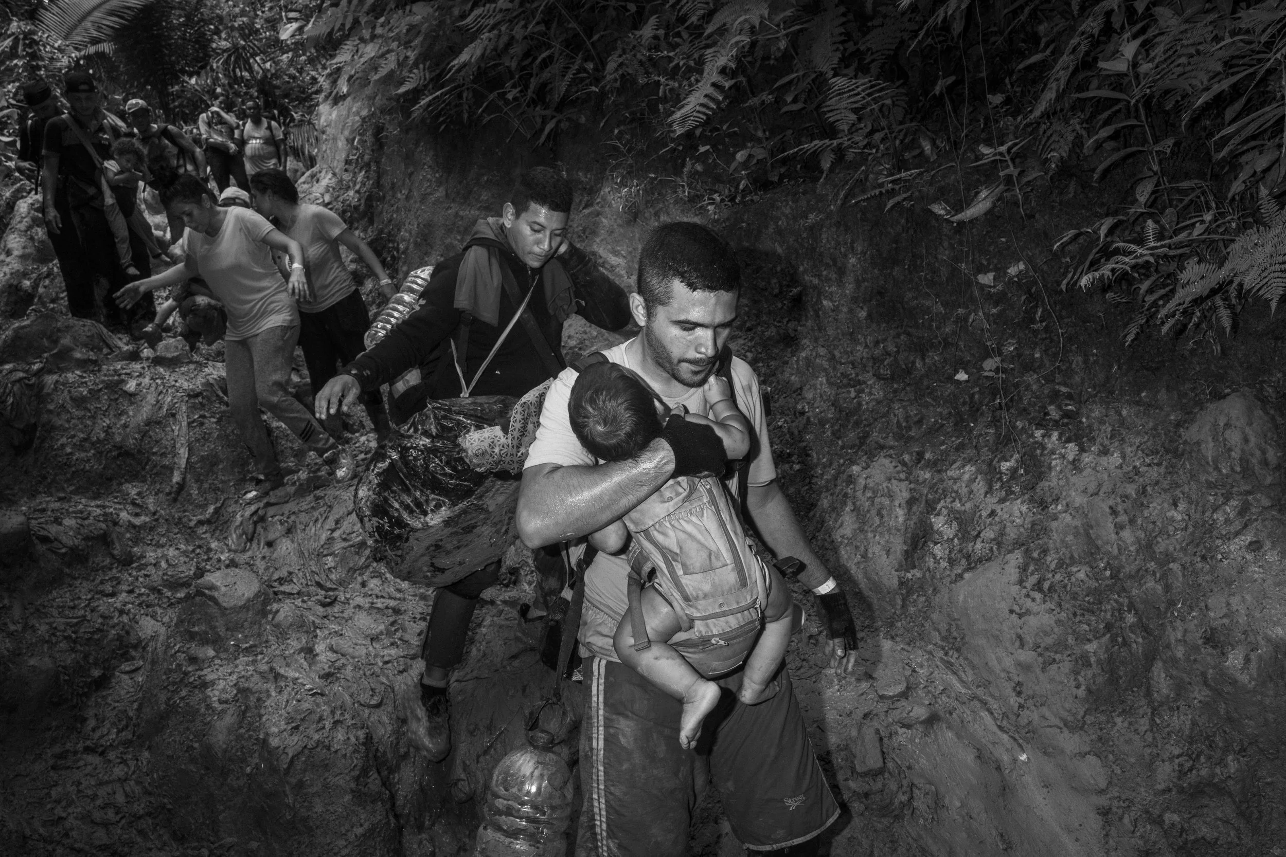 A weary César Atencio carries his six-month-old son, Simón, while navigating the treacherous Darién Gap in Colombia.
