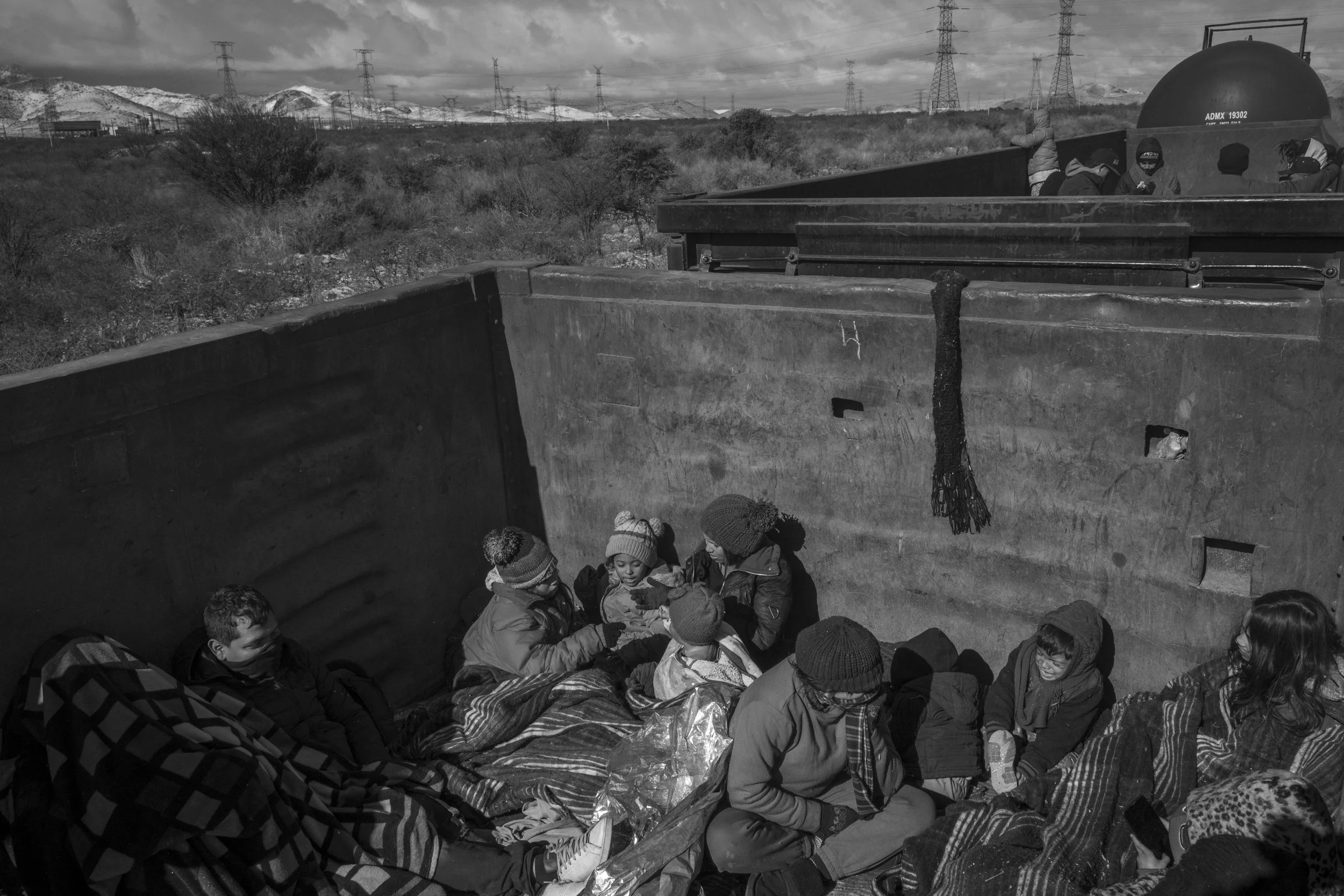 Venezuelan and Colombian migrants travel aboard a freight train heading toward Chihuahua, including Cesar Atencio, Lina Arias, and their sons, Angel and Simon.
