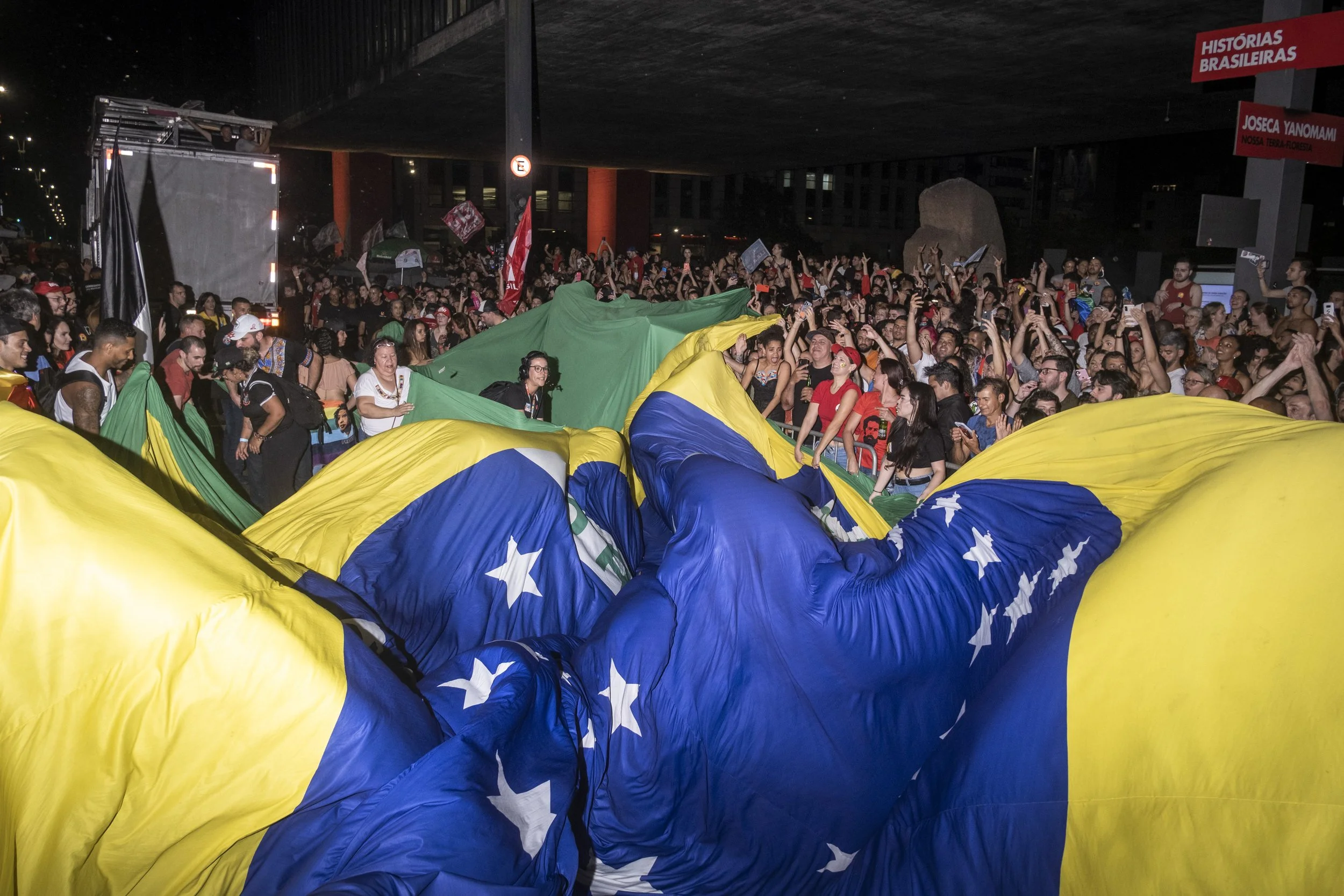 Apoiadores de Lula comemoram sua vitória eleitoral na Avenida Paulista, em São Paulo, abrindo uma bandeira do Brasil. Nos últimos anos, o símbolo nacional se tornou cada vez mais politizado, sobretudo pelo uso feito pelos apoiadores de Jair Bolsonaro
