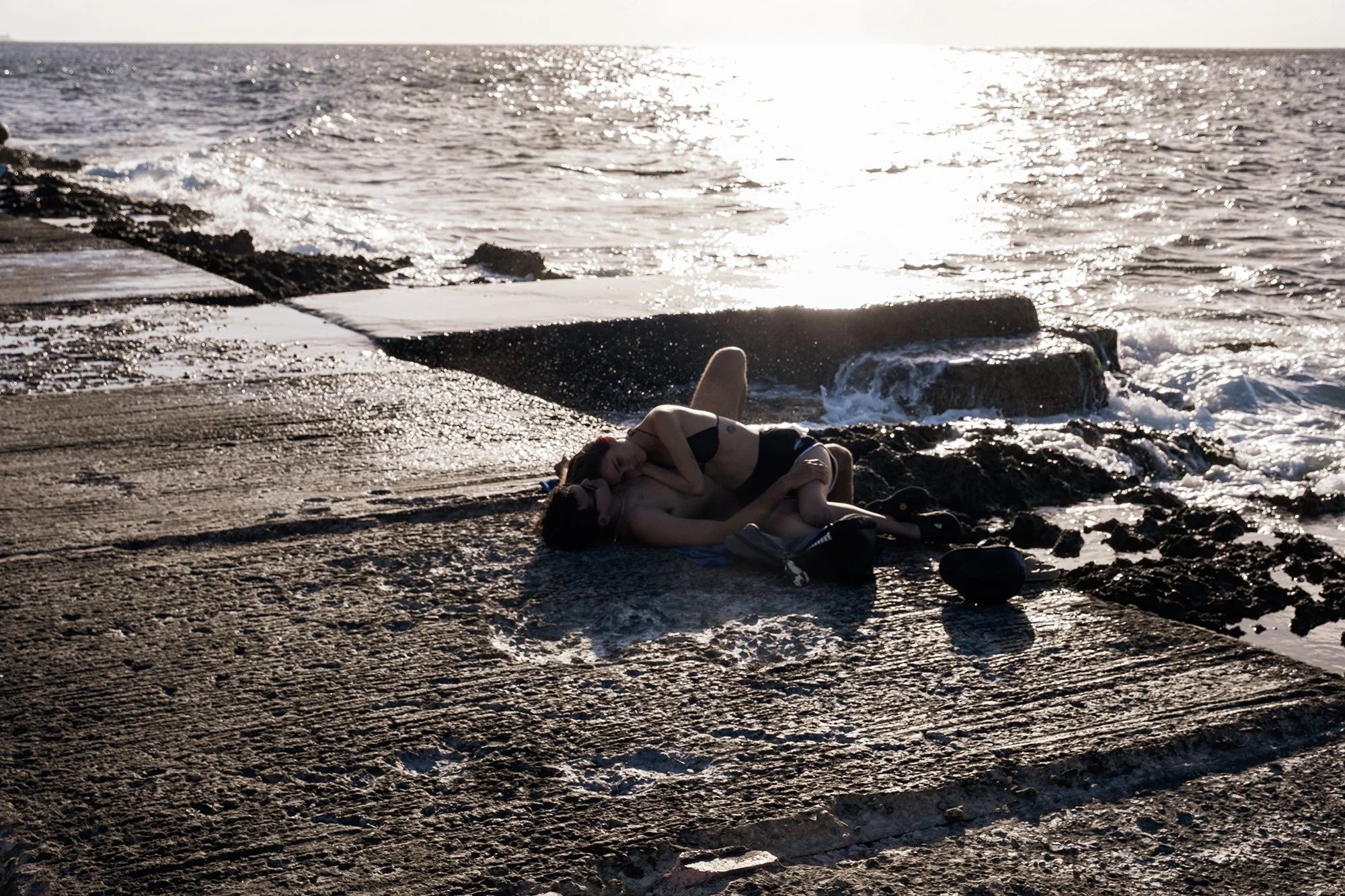 A young couple relaxes on the Malecón at sunset in Havana. 