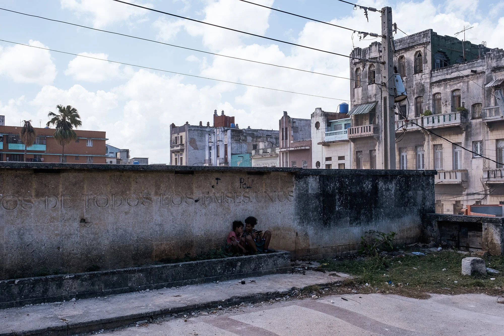 Two children play on a smartphone on a street in Havana. 