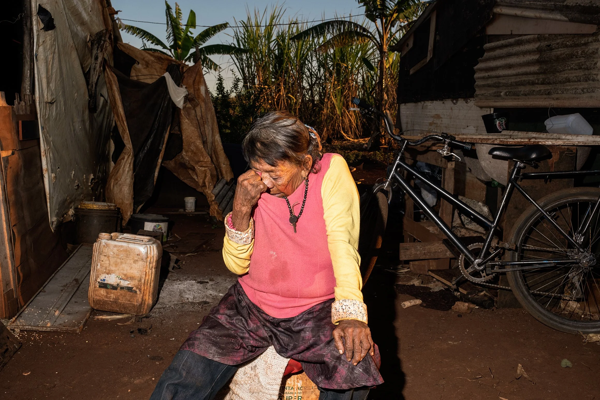 Marcelina Paulo, 89 anos, se emociona ao lembrar da mulher e da menina — suas vizinhas na retomada Guarani Kaiowá de Avaeté, perto de Dourados — que morreram em um incêndio no barraco em 30 de março de 2025. A causa ainda é investigada, mas Marcelina