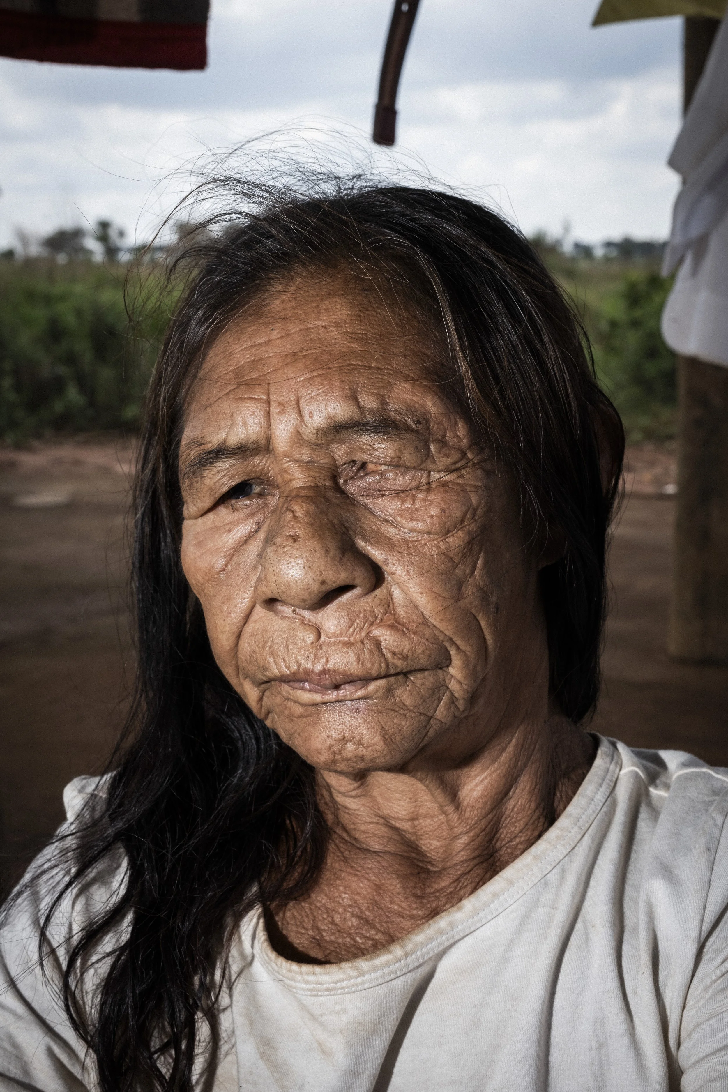 Maria Medina (82), mulher indígena Guarani que vive em uma pequena palhoça próxima à comunidade Serrito, em Mato Grosso do Sul, enfrenta insegurança alimentar em meio a disputas por terra, isolamento e falta de trabalho. Como muitas famílias da regiã