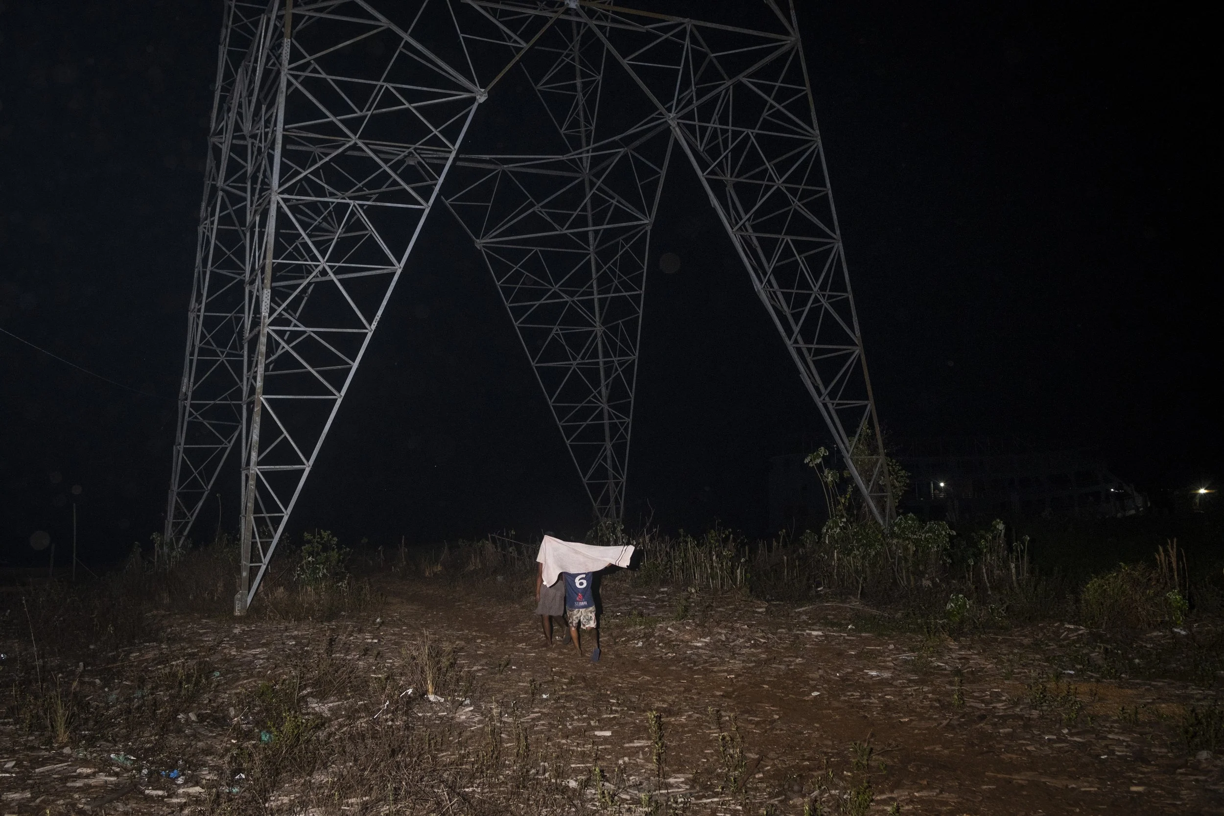 Dois meninos caminham sob uma torre de energia elétrica a caminho do rio onde vão se banhar, em Breves, cidade localizada na Ilha de Marajó, no estado do Pará. A região apresenta o menor índice de desenvolvimento socioeconômico do país.