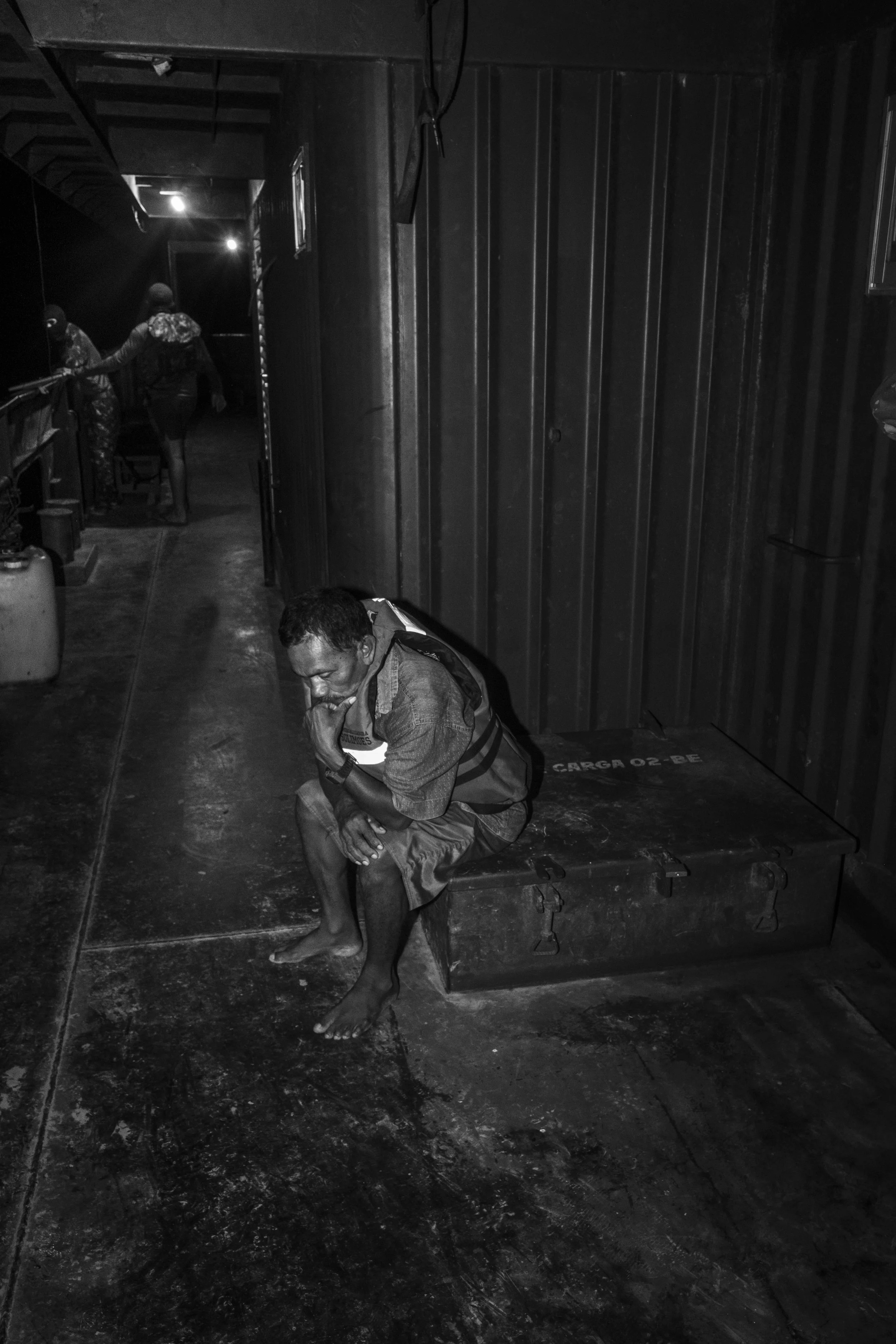 A fisherman waits to be questioned by Brazilian Army soldiers after his boat was intercepted at night on the Solimões River, near the community of Capacete. Soldiers seized a cargo of illegally caught Amazonian fish, including the valuable pirarucu. 