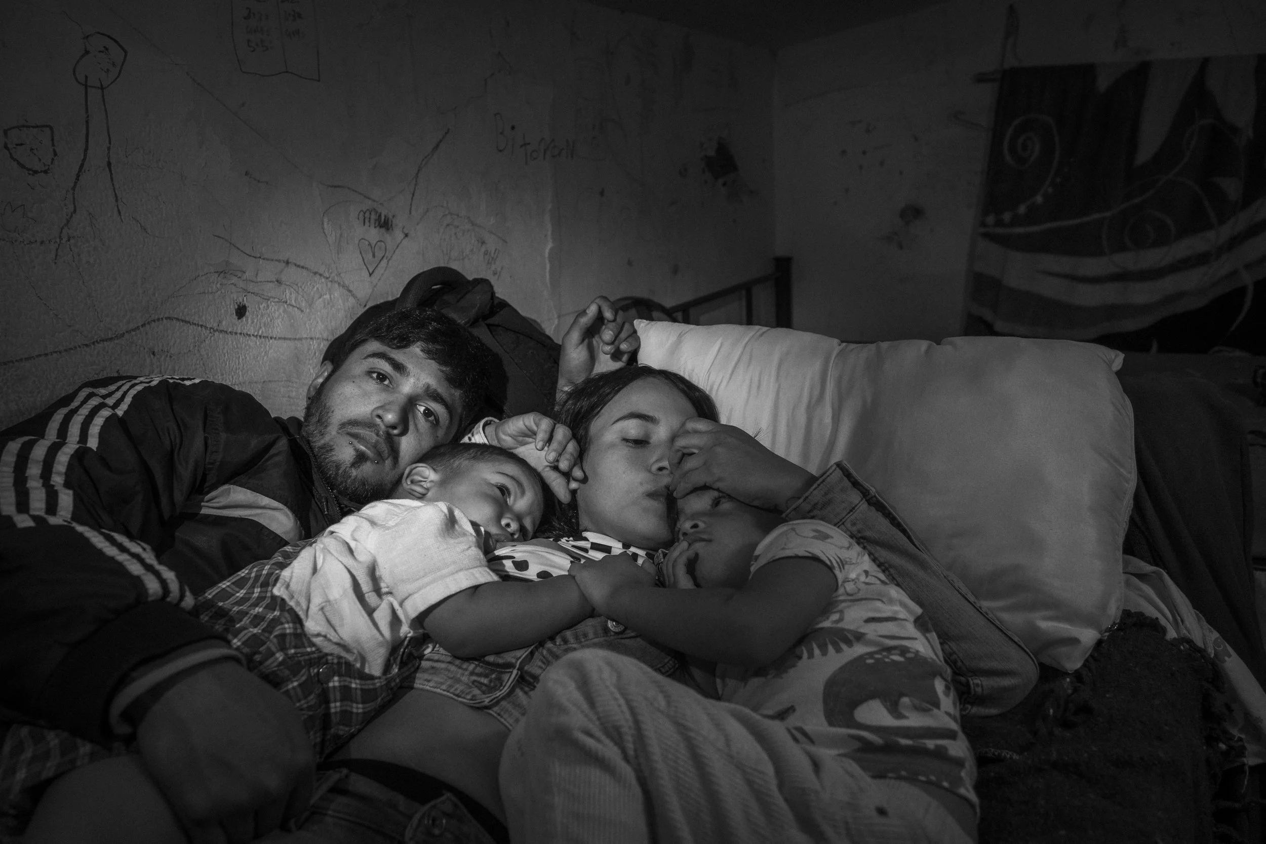 Cesar Atencio and Lina Arias, with their sons Ángel and Simón, rest on a bunk bed in a migrant shelter in Ciudad Juárez after surviving a 25-day kidnapping in the Chihuahuan desert.