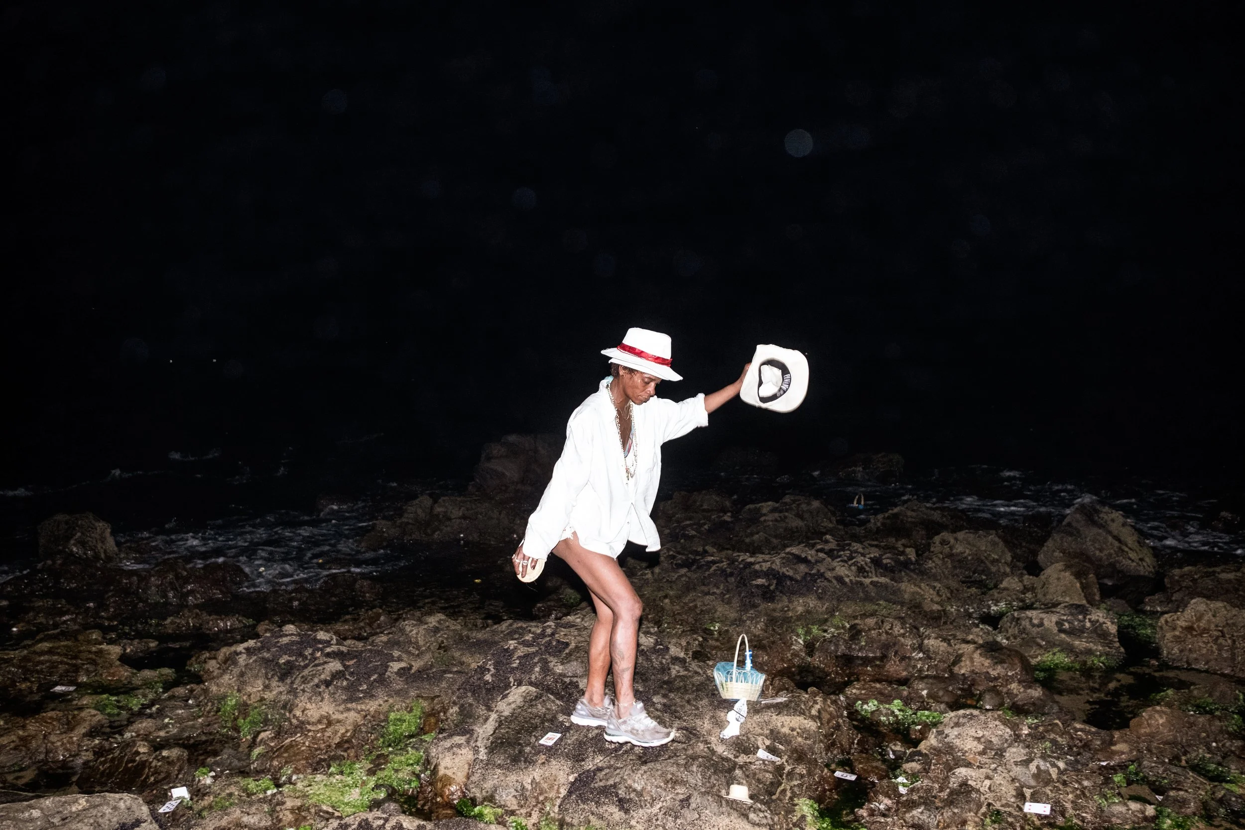 Uma mulher sob efeito de álcool e transe espiritual na praia do Rio Vermelho, em Salvador, durante as celebrações de Iemanjá — a orixá das águas salgadas, amplamente reverenciada nas religiões Candomblé e Umbanda. A festa reúne milhares de devotos qu