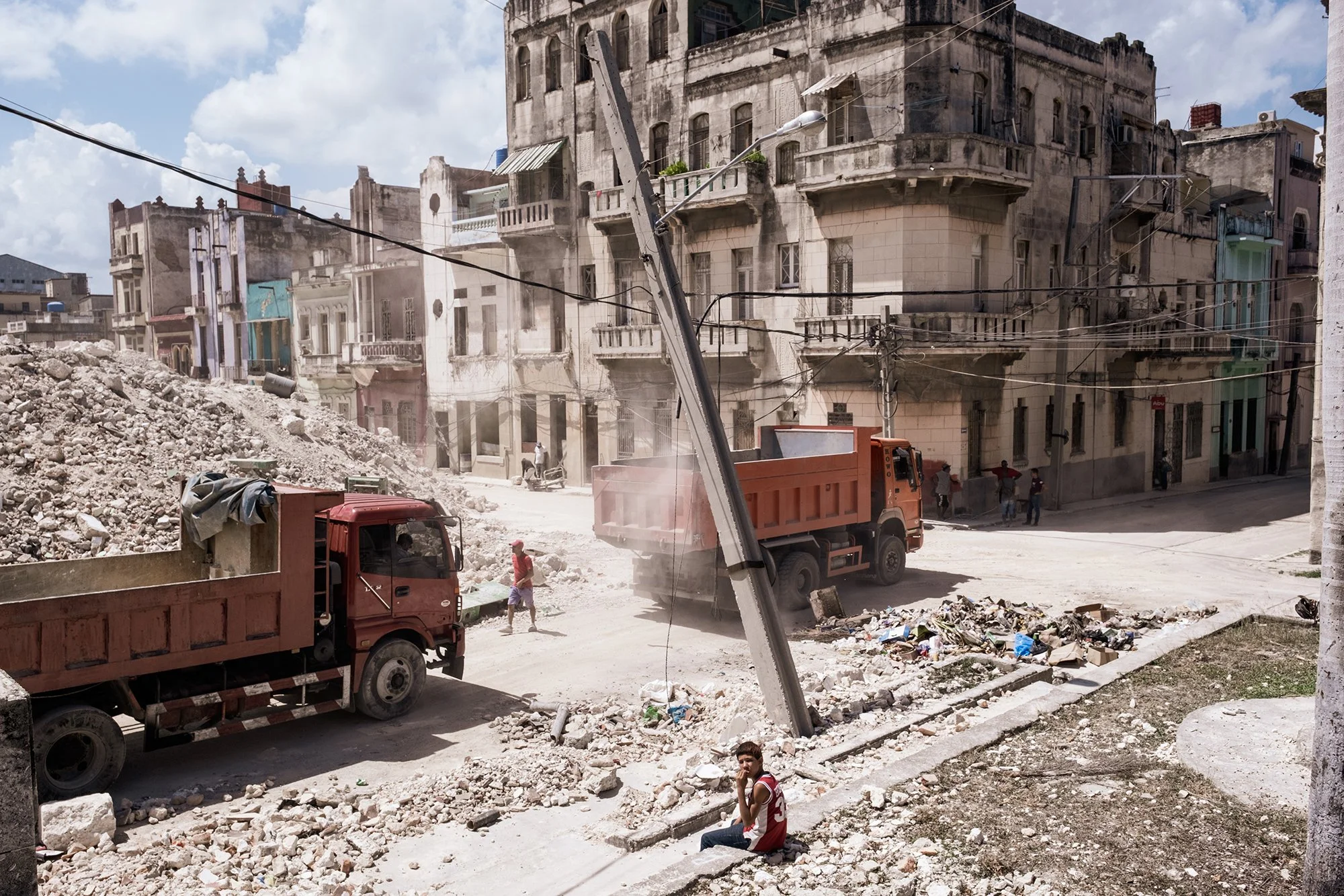 Trucks remove rubble from the recently collapsed Building G at the University of Design in Havana.