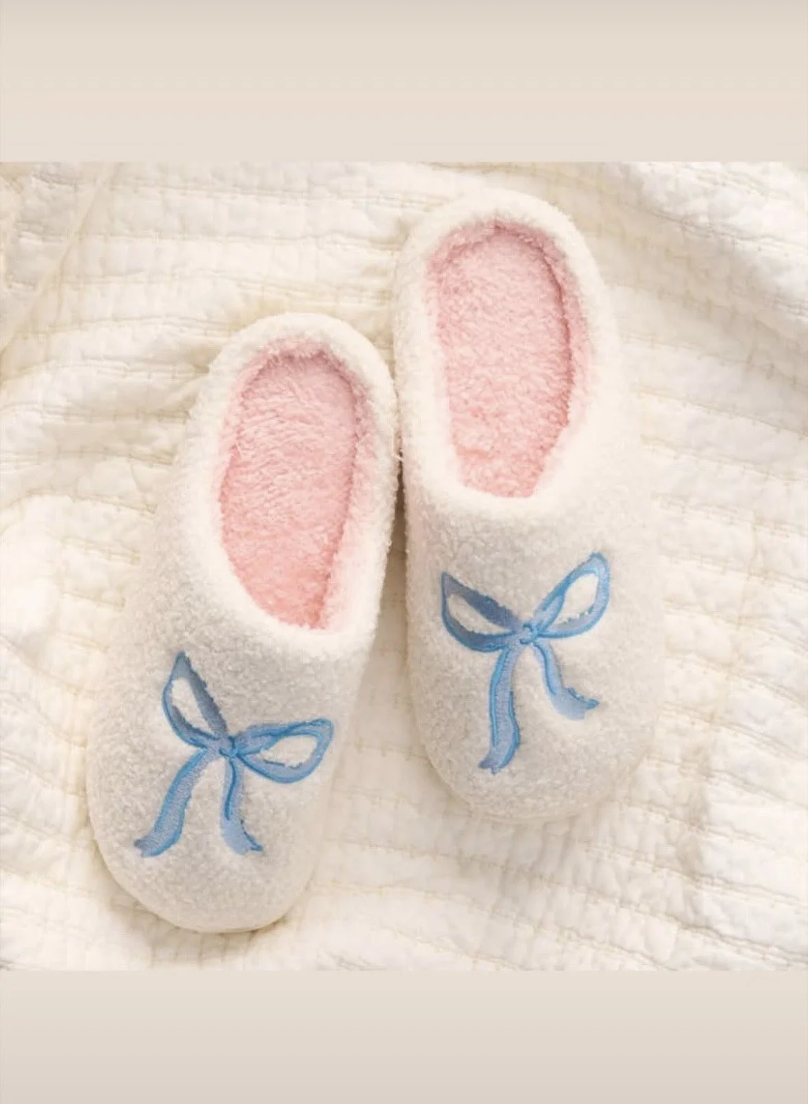 White slippers with blue bow.