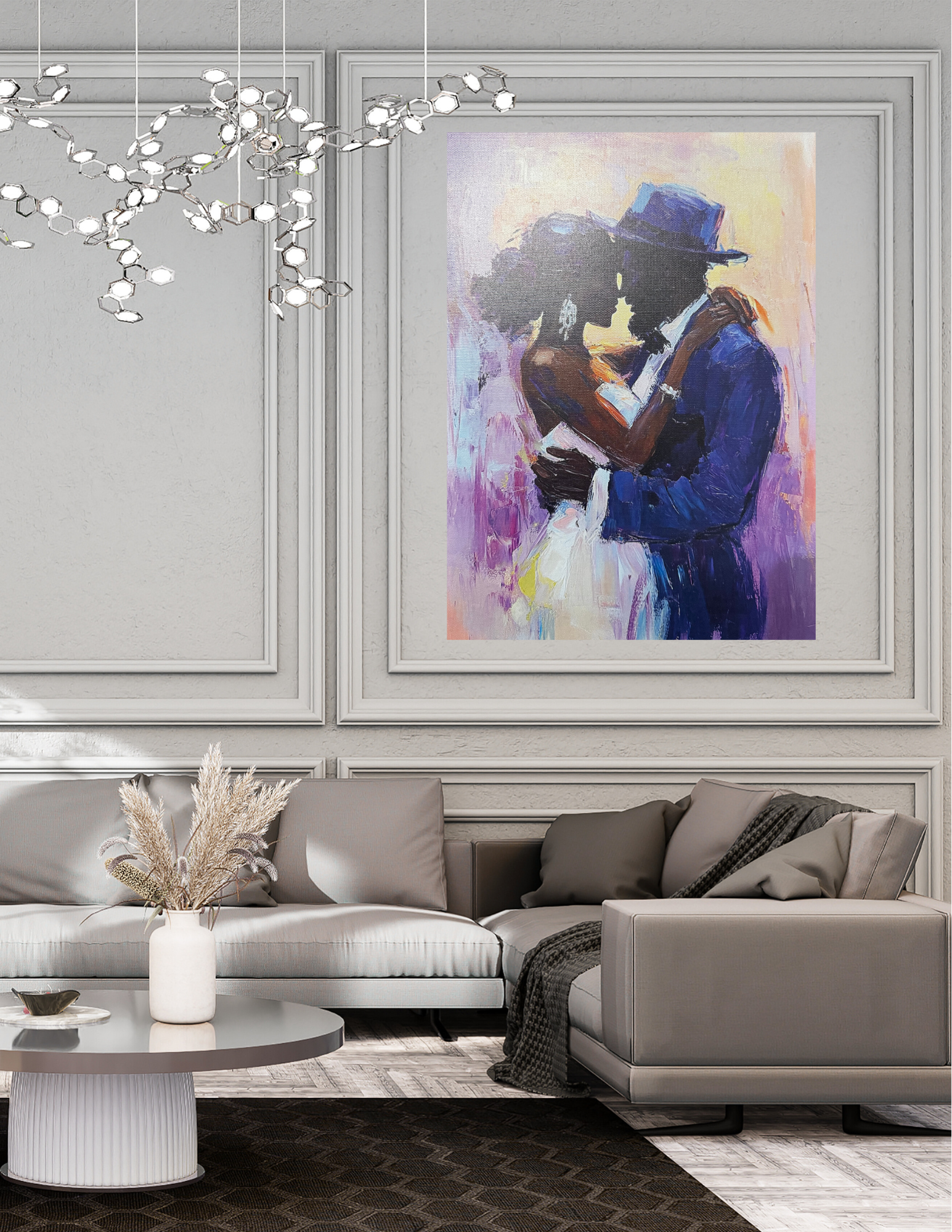 Living room with a modern gray sofa, a white vase with dried flowers on a round coffee table, and a colorful painting of a couple embracing on the wall.