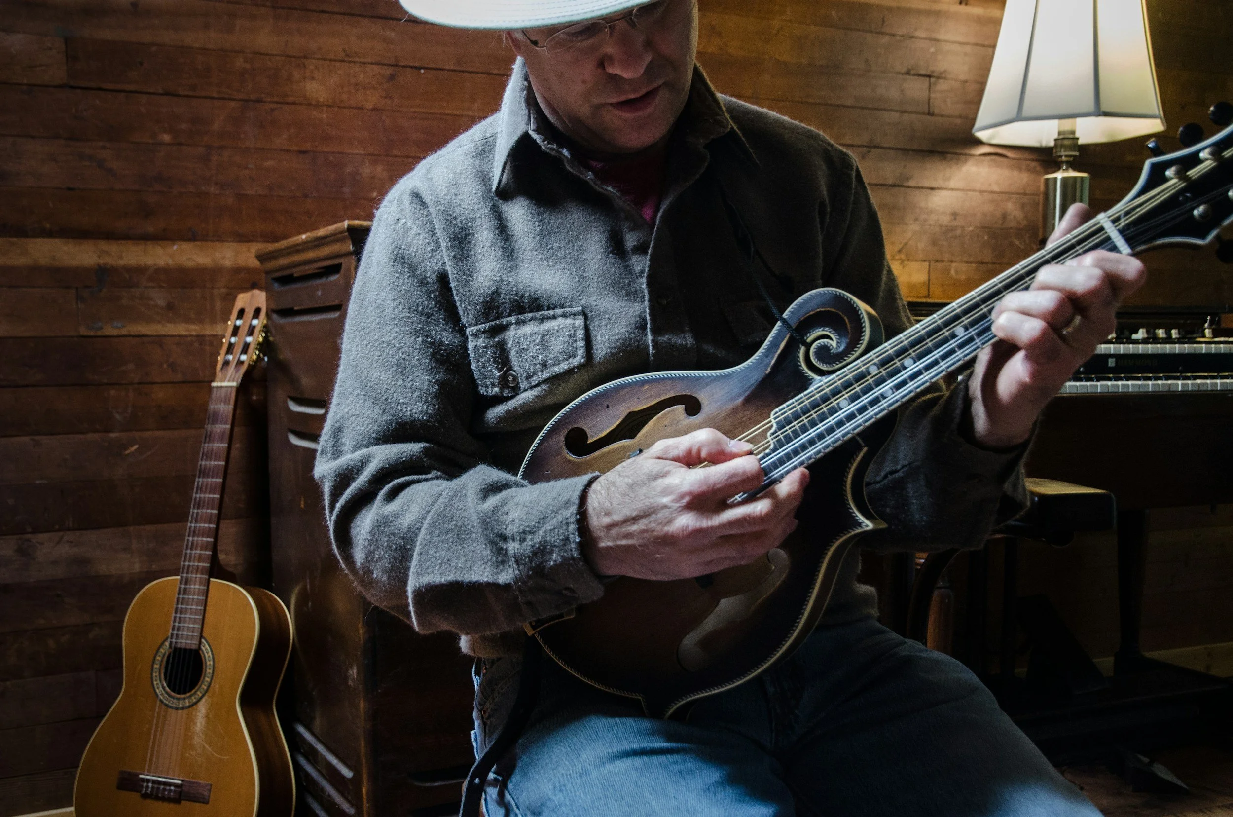 Musician playing a mandolin with his fingers and a pick