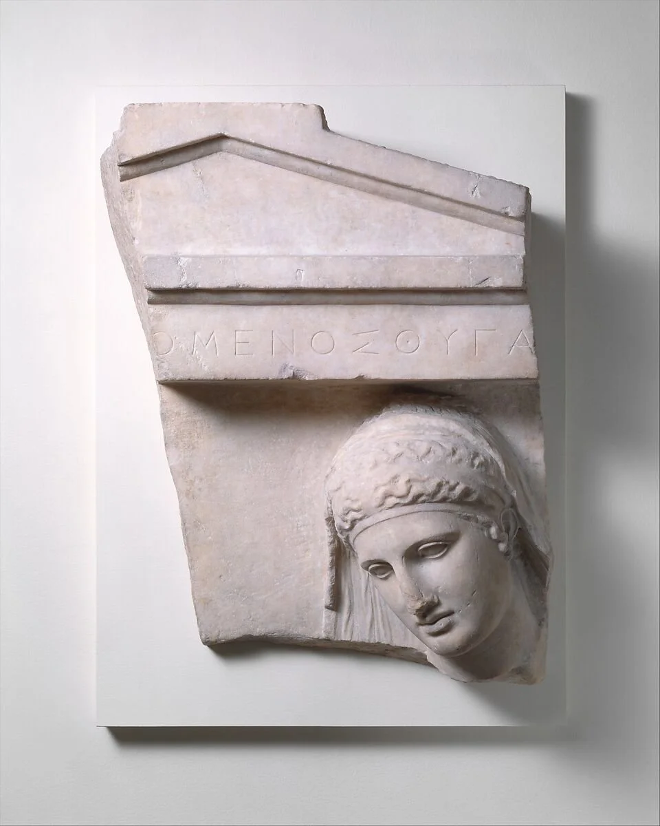 Ancient Greek marble sculpture of a woman’s face with a serene expression, featured in a blog post about music therapy for advanced dementia, emotional well-being, connection, and distress reduction in care settings.