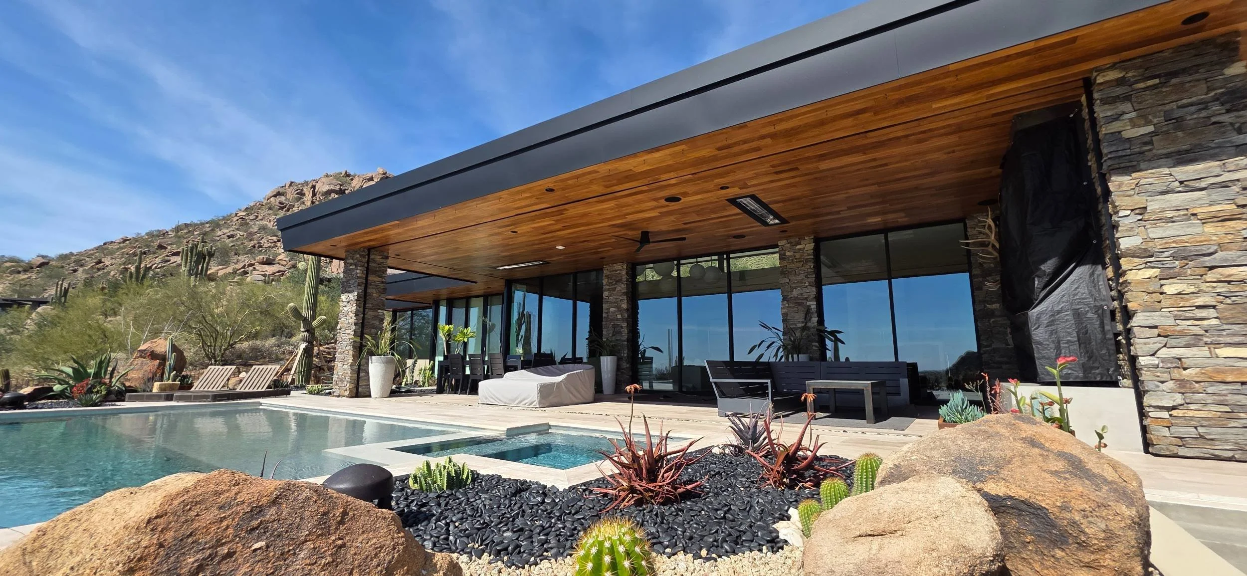 A custom pool and spa surrounded by desert landscape design in Anthem, AZ