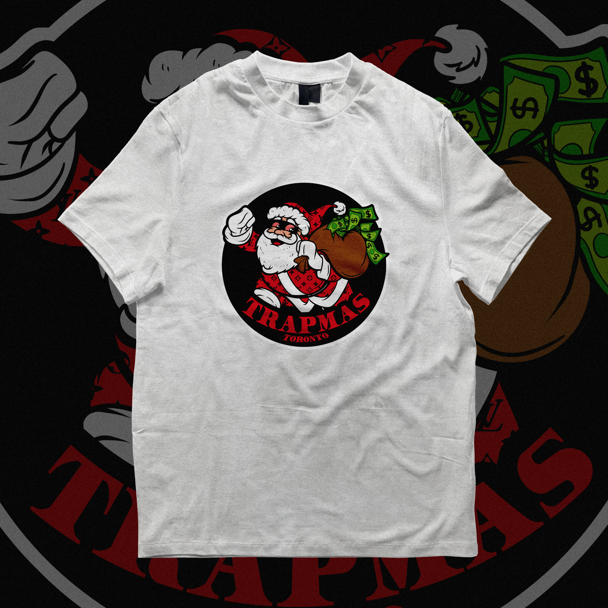 A white T-shirt with a graphic logo featuring Santa Claus holding a large bag of money. The logo includes the text 'TRAPMAS TORONTO' in red. The background of the logo is black with a red border.