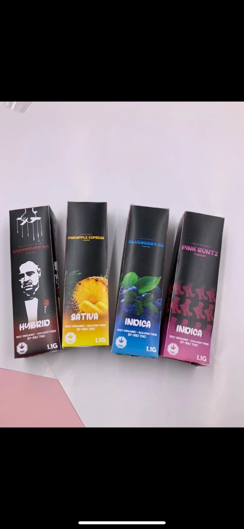 Four vape cartridges in black packaging labeled hybrid, sativa, indica, and indica, each featuring cannabis strain names and THC content, arranged on a white surface.