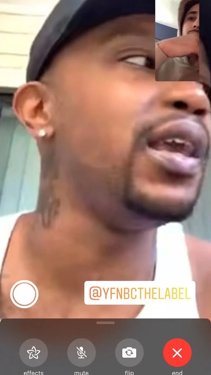 Close-up of a man with earrings and a black cap talking, with a small inset of a woman resting her head on her hand during a video call.