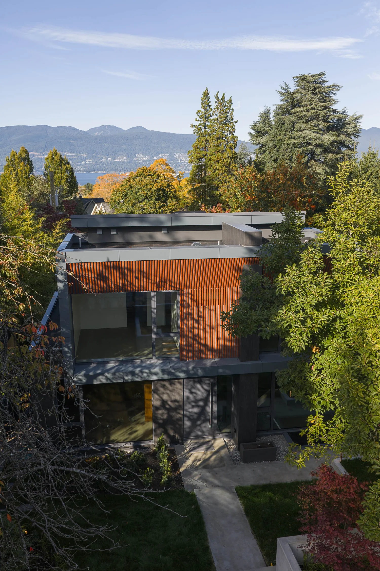 Looking down over the flat roof and slatted upper storey to distant water and mountains