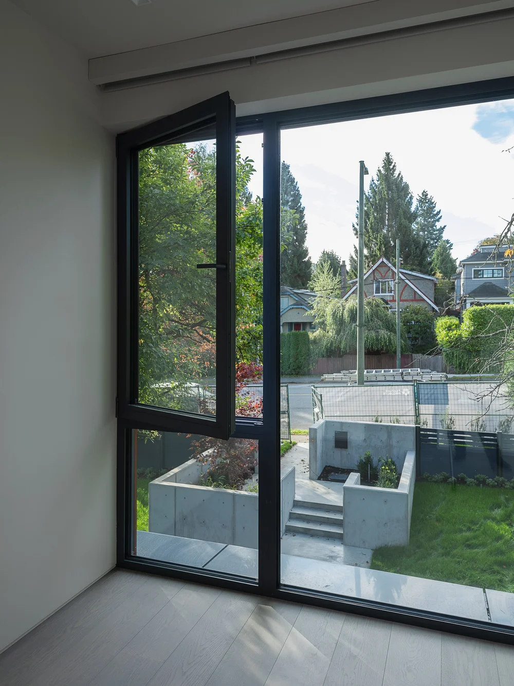 Corner glazing over the concrete garden walls to the houses across the street
