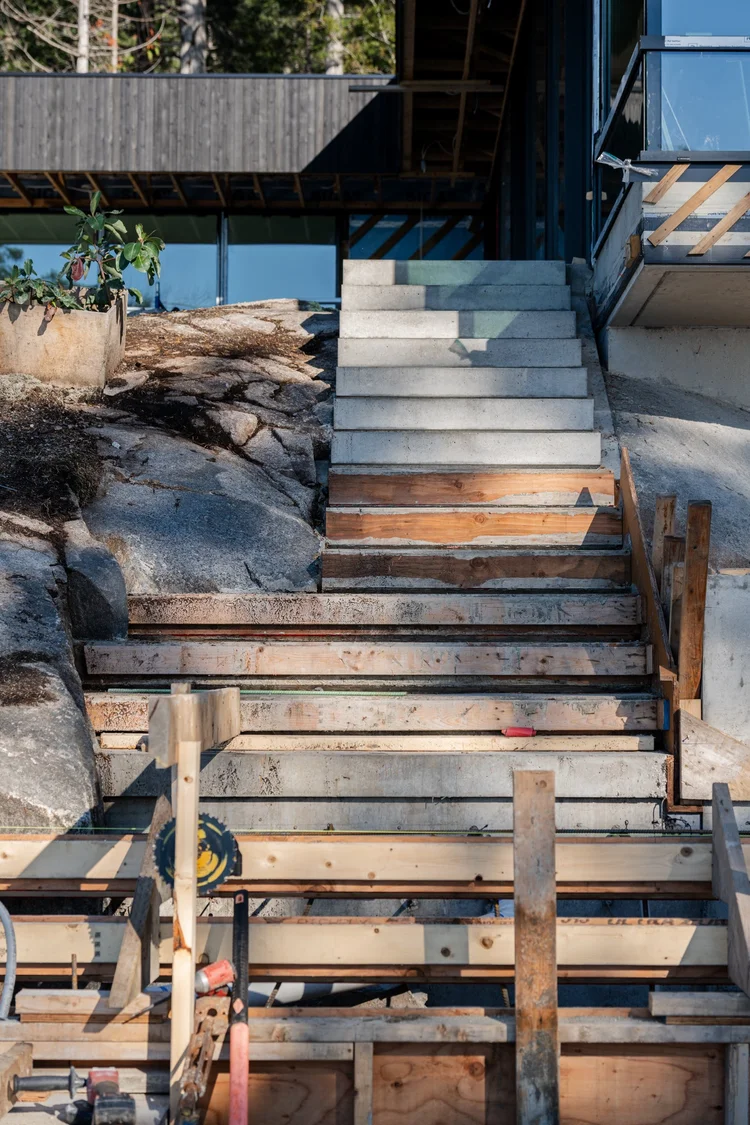 Concrete stairs being formed on a rock outcrop, steel and timber framing