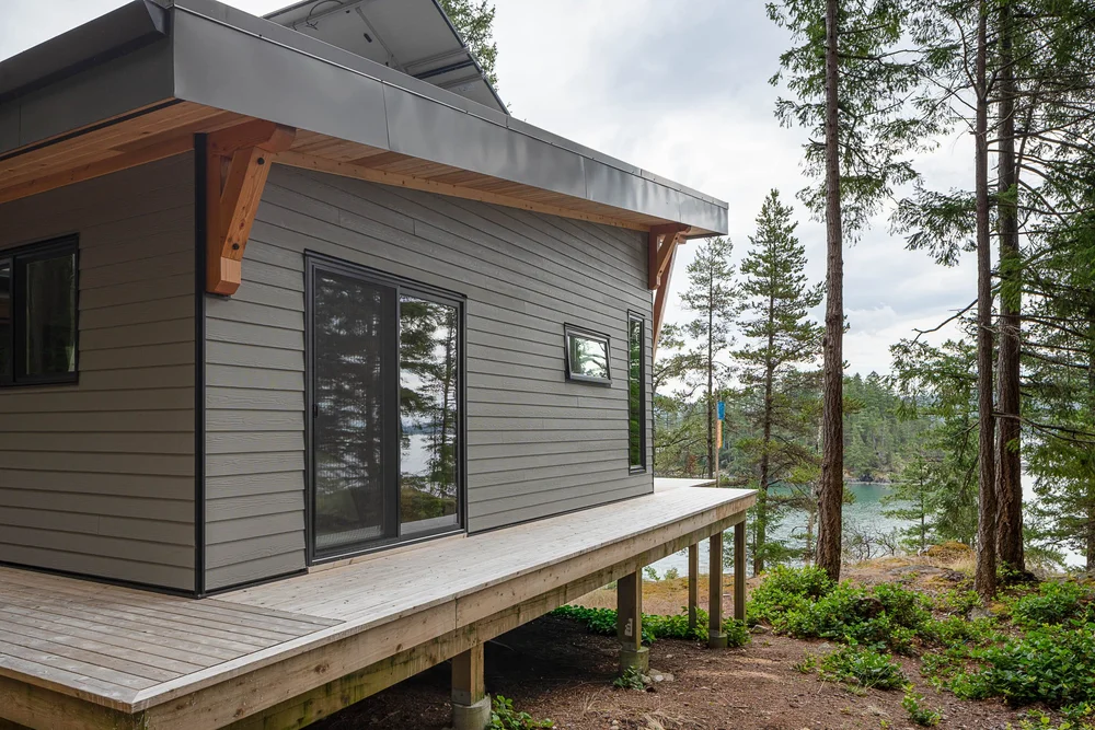 End wall and window under a deep overhang, the deck carried on wood posts