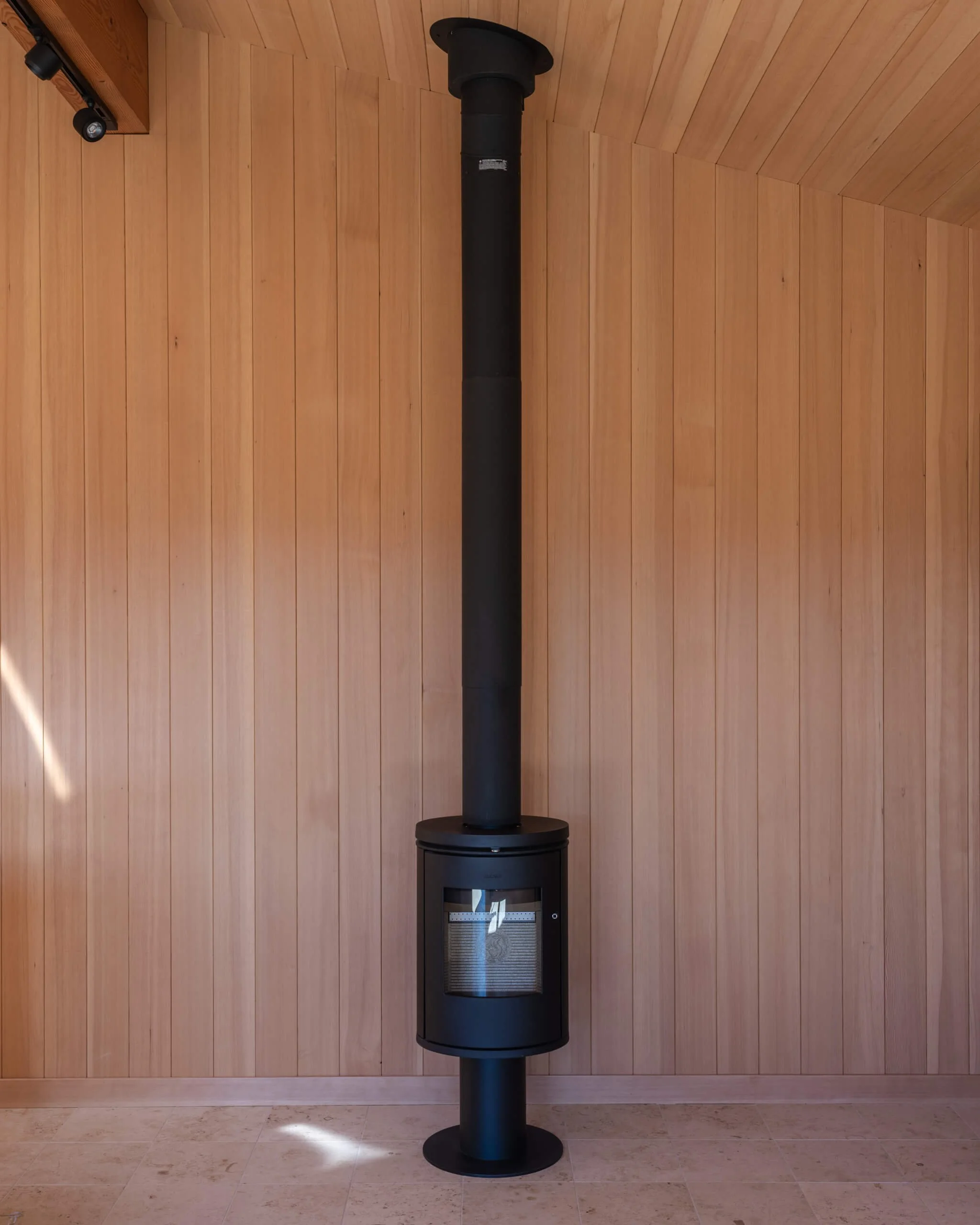 desolation-sound-residence-cabin-wood-stove-fir-wall-architectural-photographer-matt-anthony.jpg