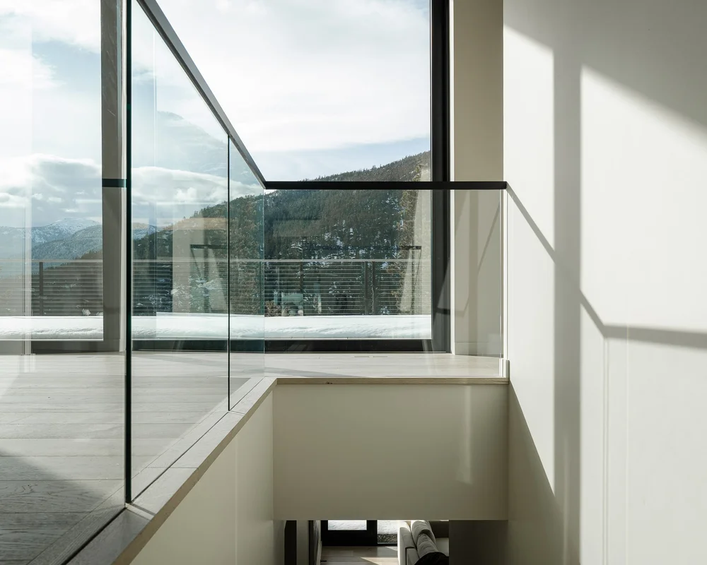 Clerestory glazing above a stair, sunlight falling across the white wall