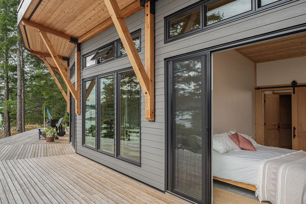 A sliding door open from the deck to a bedroom, wood braces along the wall