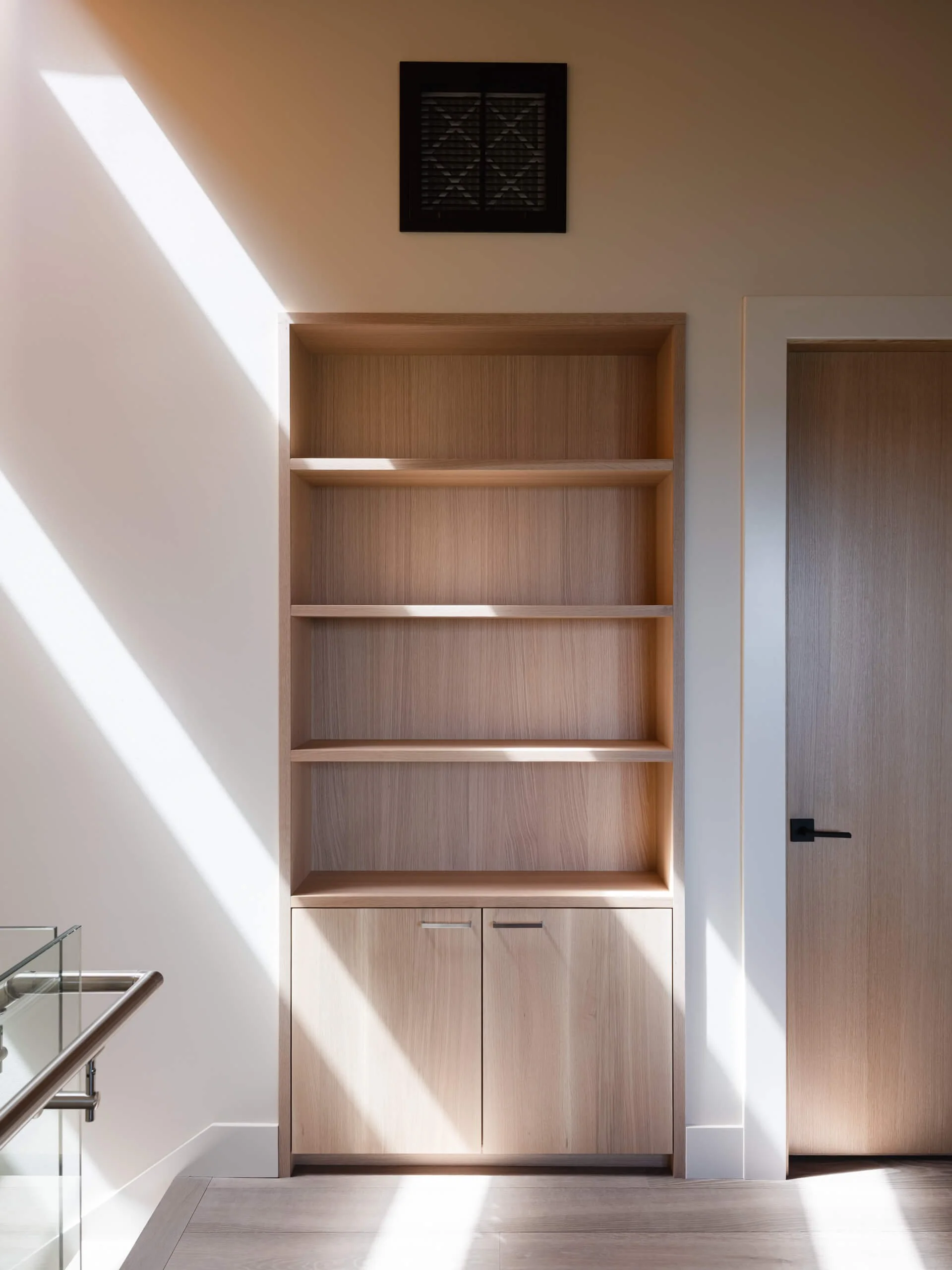 desolation-sound-residence-oak-bookcase-sunlight-architectural-photographer-matt-anthony.jpg