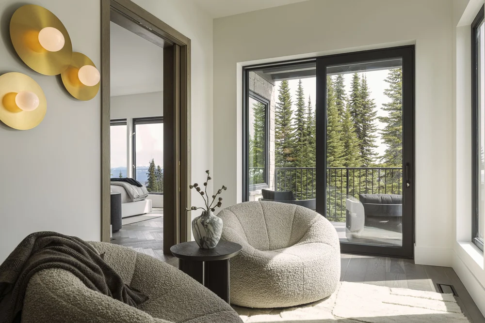 Sitting corner with a round upholstered chair, a tall mirror and three round wall lights