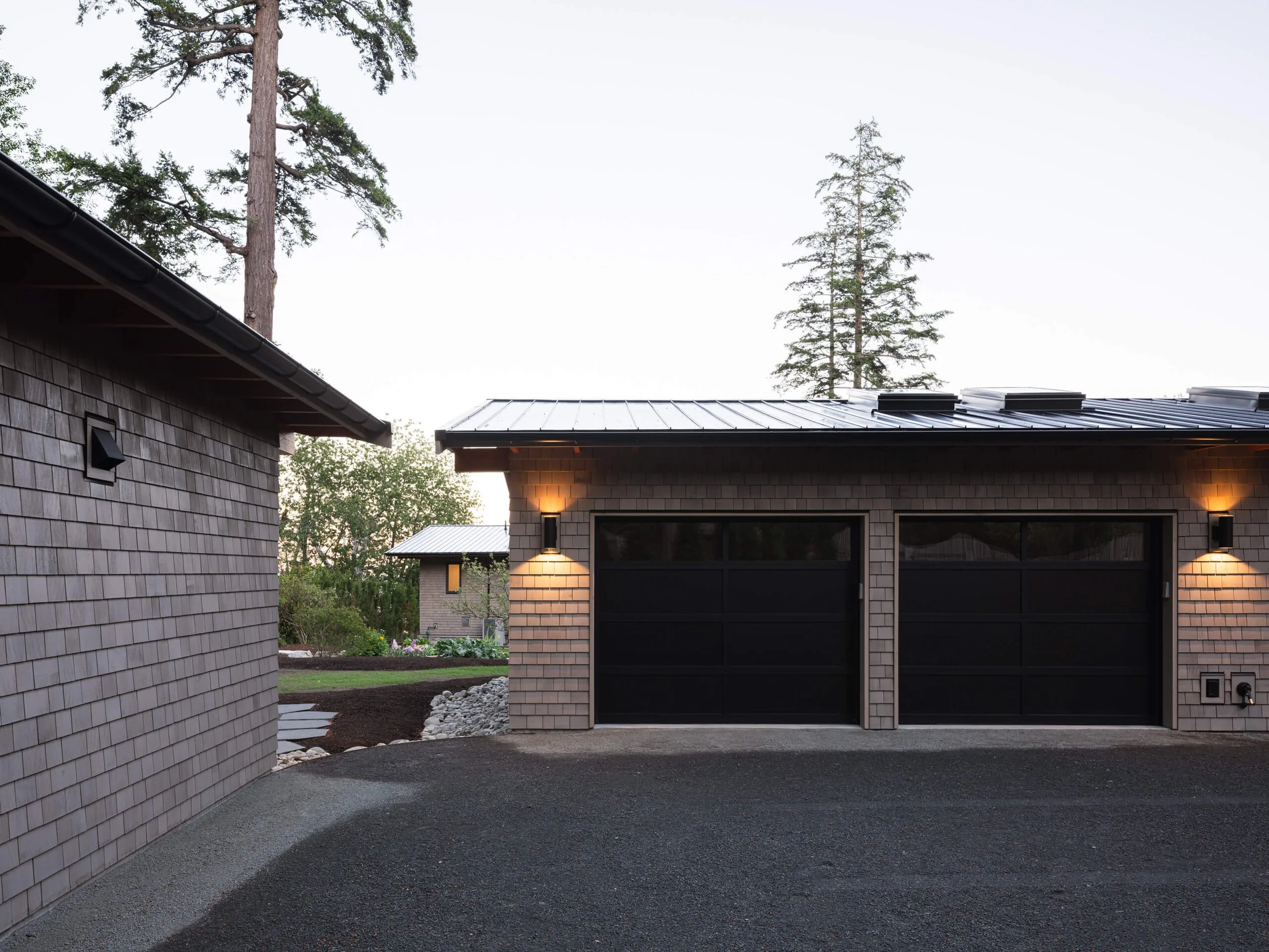 desolation-sound-residence-dusk-garage-doors-lit-sconces-architectural-photographer-matt-anthony.jpg