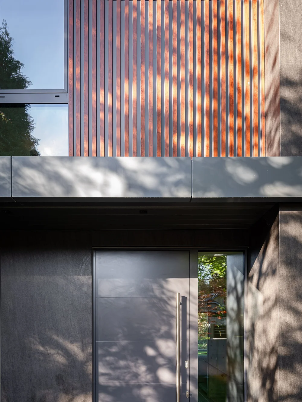 Wood slats above the door, its long pull handle catching the afternoon light