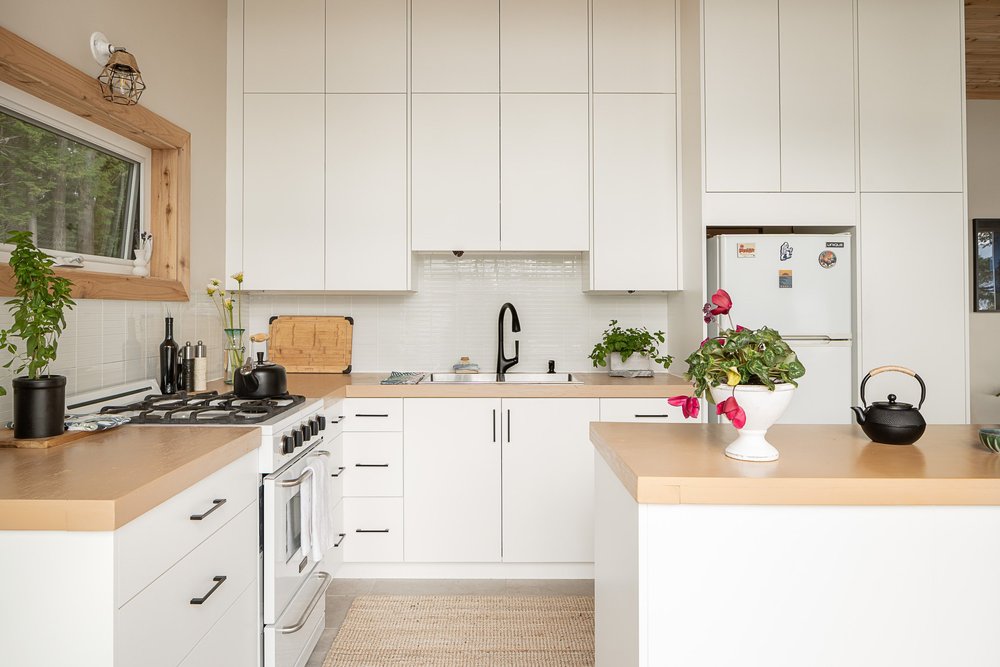 The kitchen from the dining side, island counter at right and white cabinets beyond