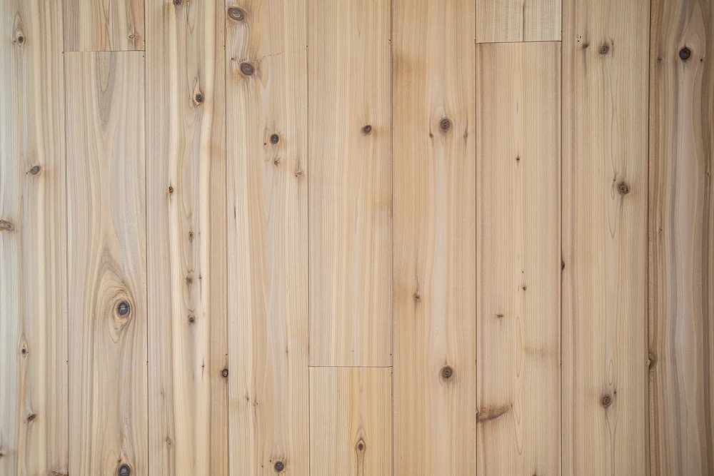 A wall of wood boards filling the frame, knots and grain in even light