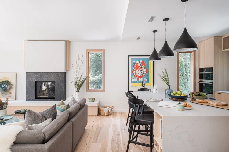 Open plan living and kitchen, the fireplace at one end and the island at the other