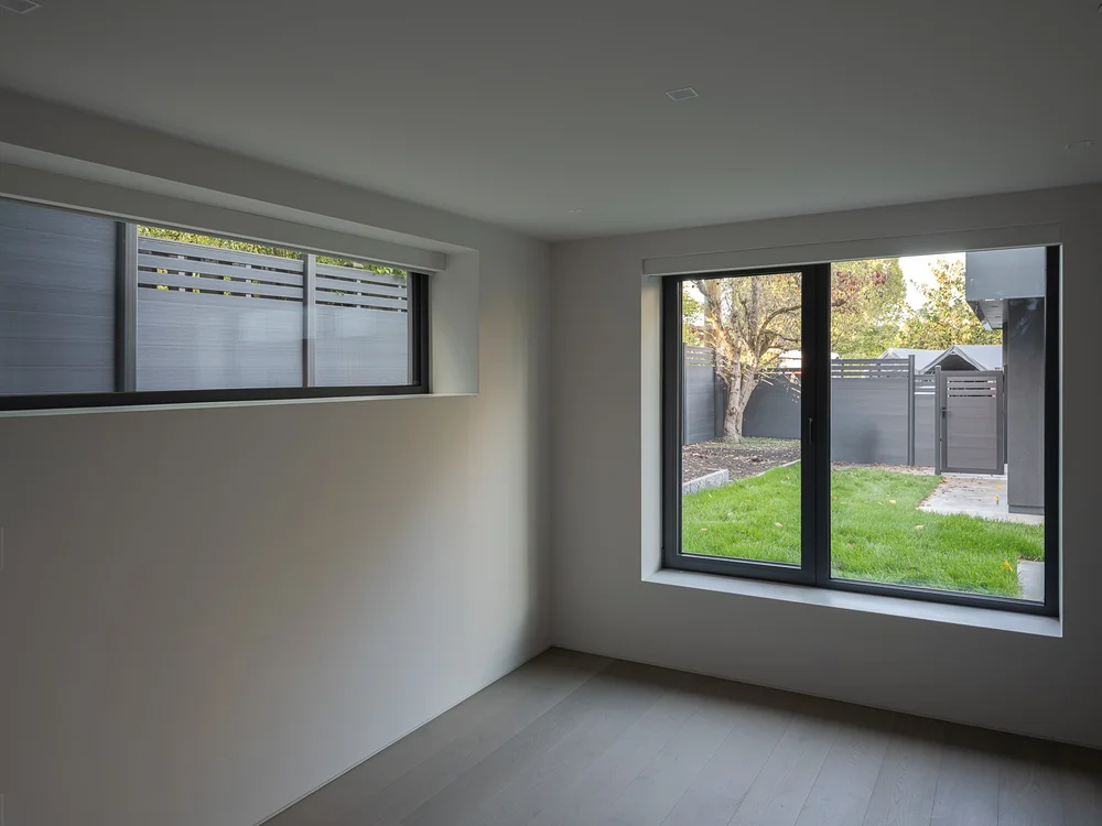 Lower room with a long clerestory and a window onto the lawn and fence