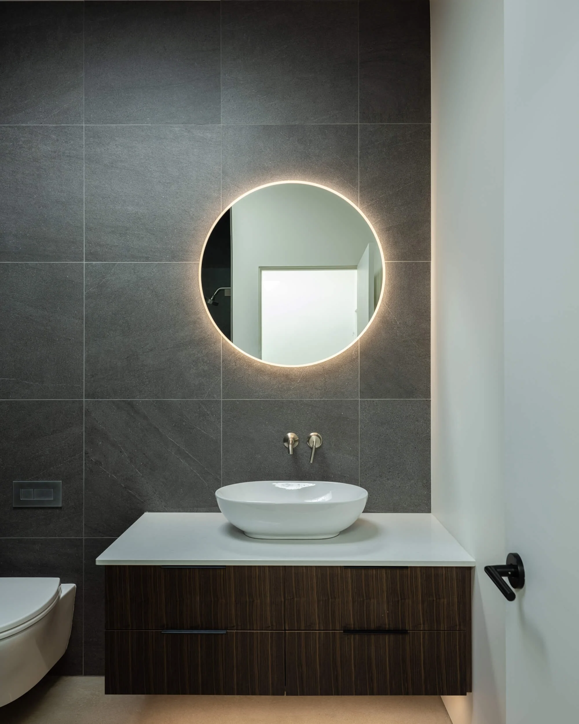 johnstone-road-madeira-park-powder-room-backlit-round-mirror-architectural-photographer-matt-anthony.jpg